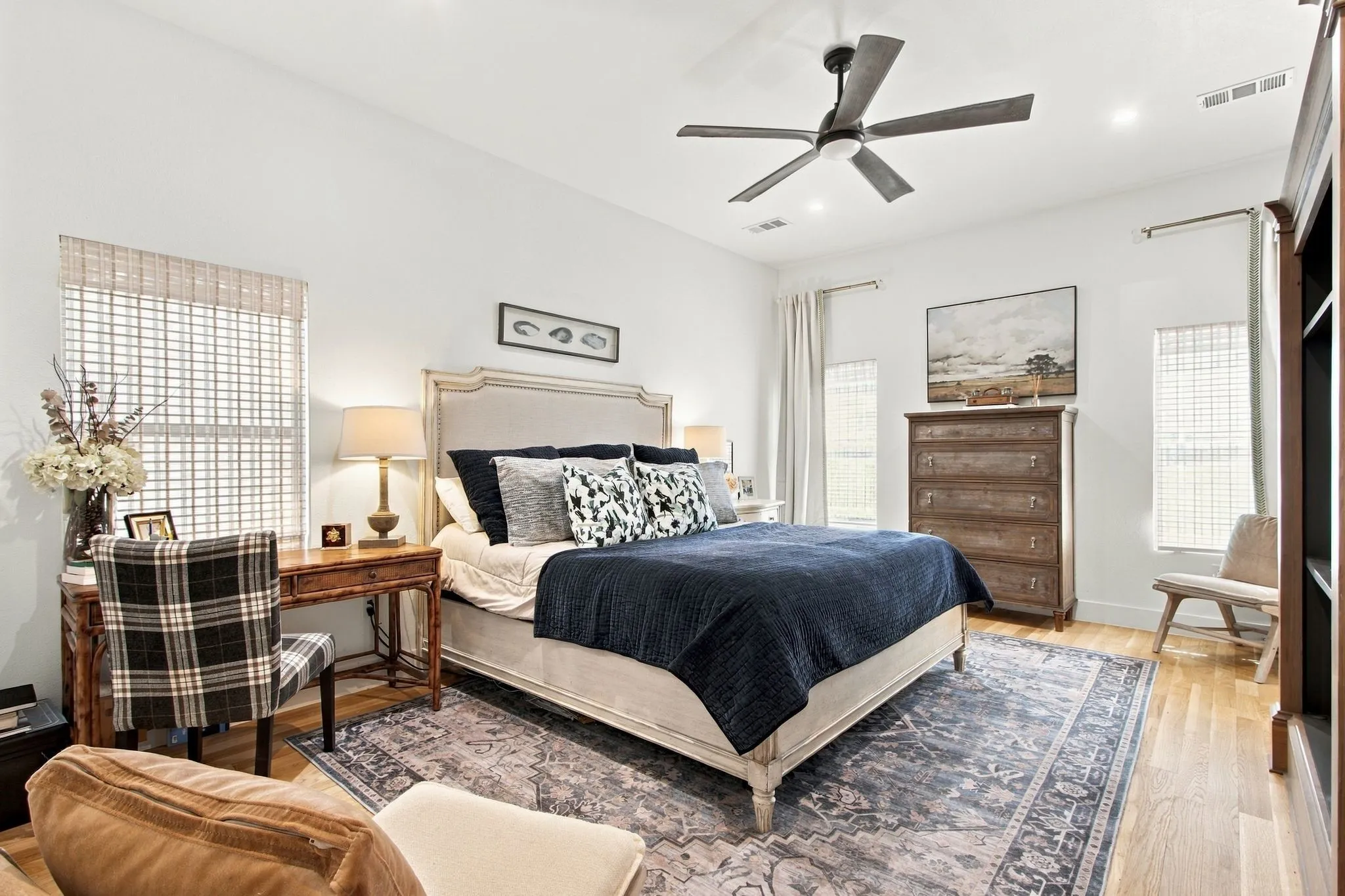Recessed lighting, wood-finish flooring, ceiling fan with light, and multiple windows with woven blinds