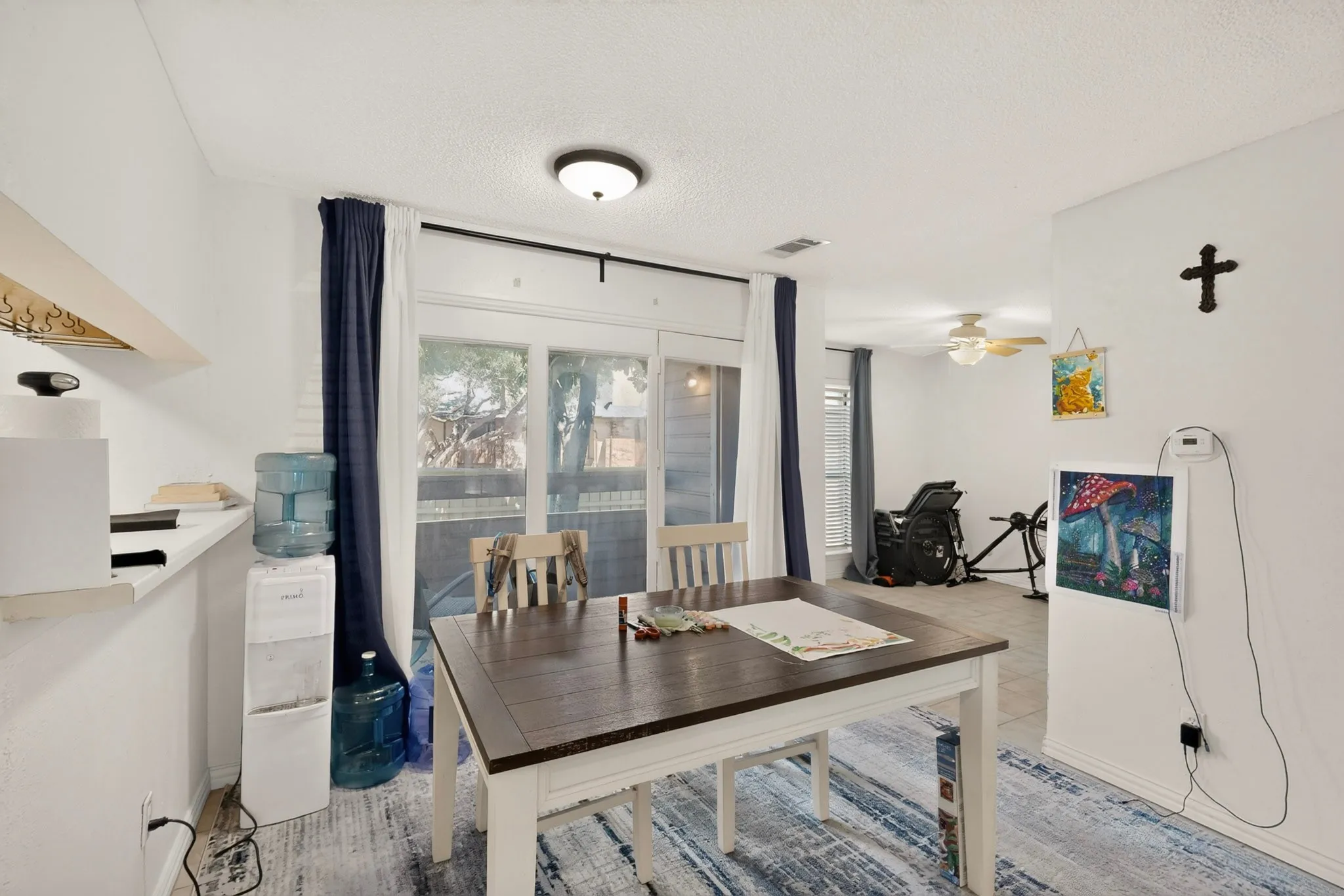 White walls with a textured ceiling and a flush-mount light fixture
