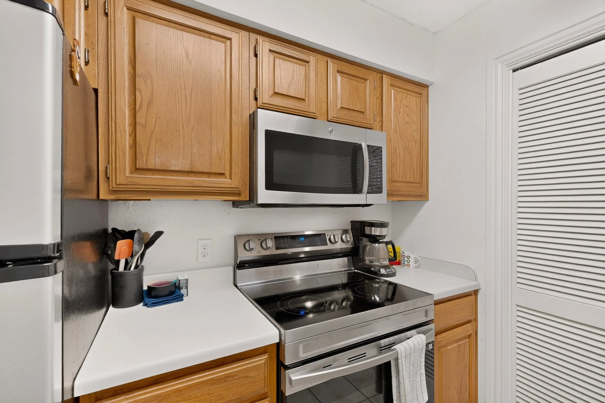 Kitchen featuring stainless steel appliances, wood-finish cabinetry, and solid surface countertops