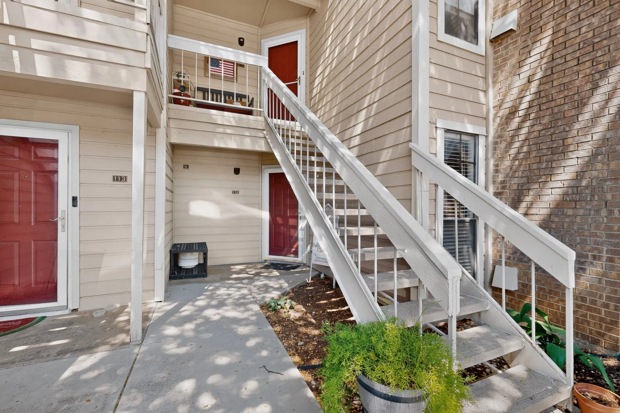 Tan siding exterior with red entry doors