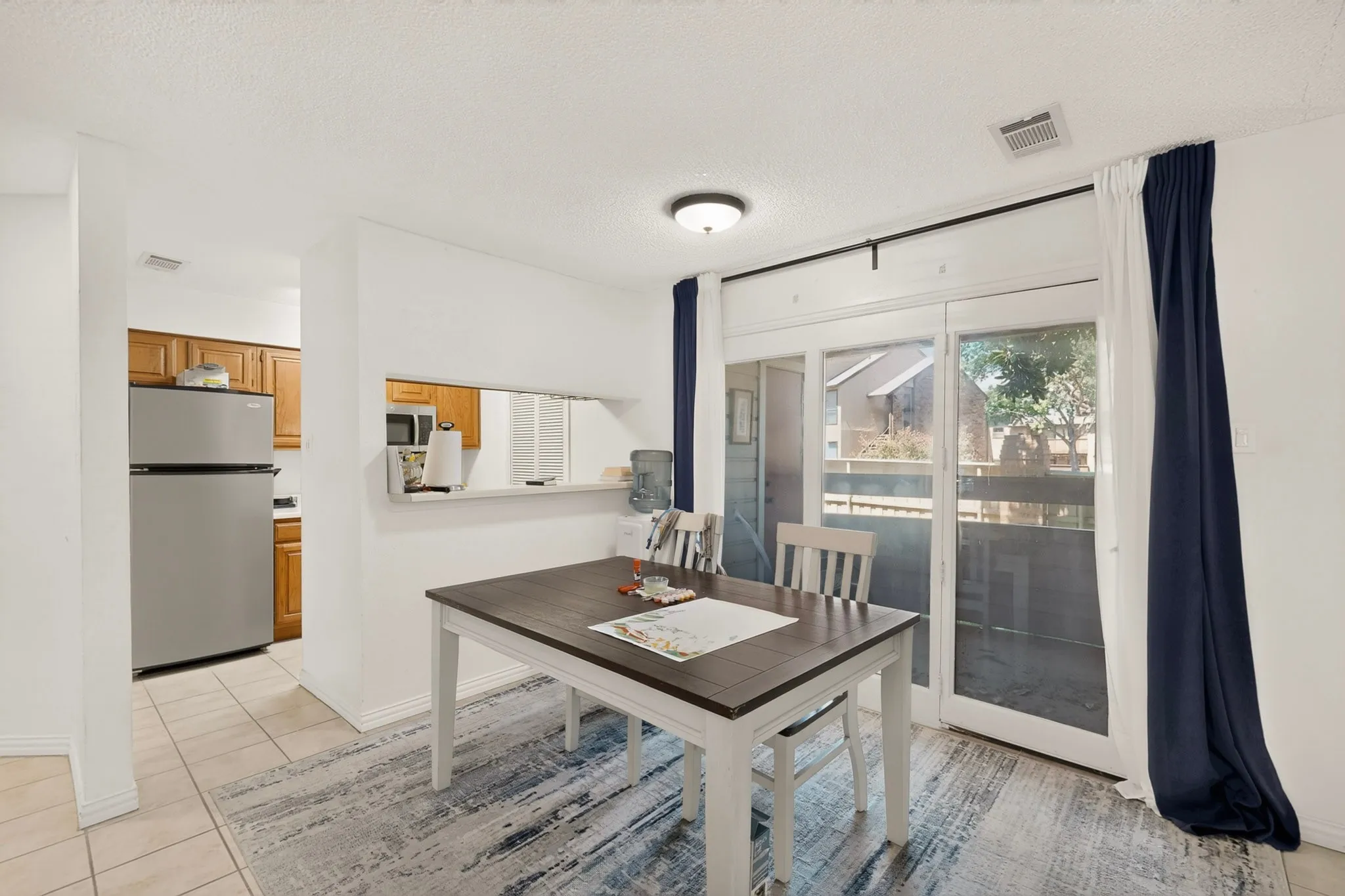 Dining area with wood-finish flooring, a pass-through window, and sliding glass doors