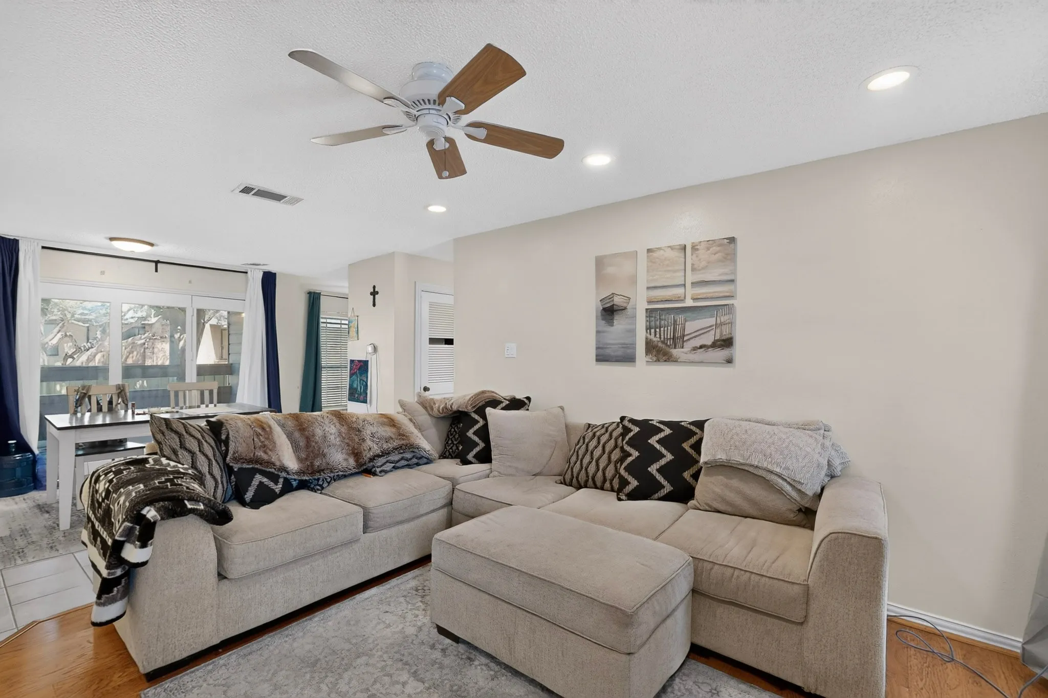 Open concept living area with wood-finish flooring, recessed lighting, and a ceiling fan