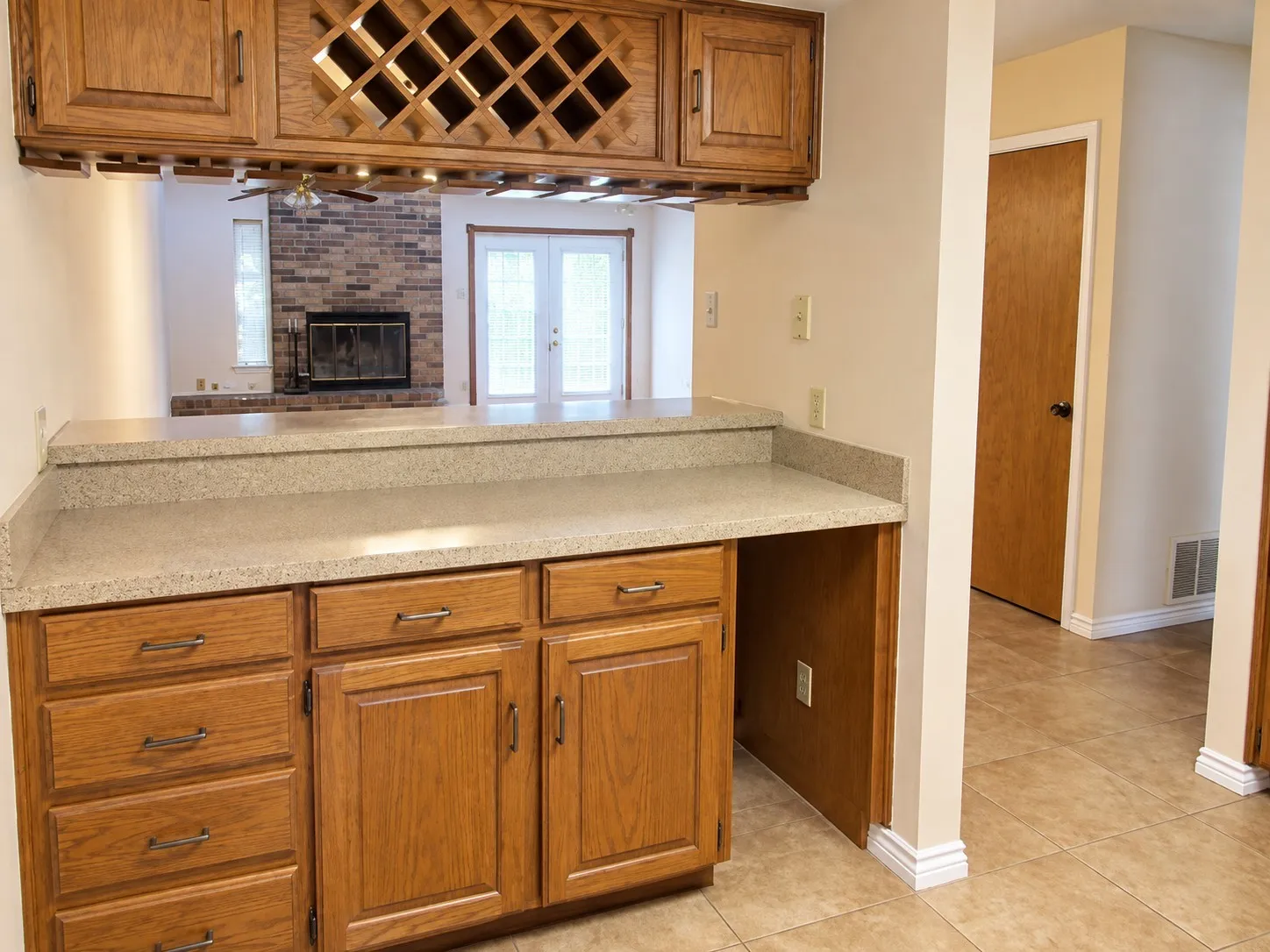 203- Built-in bar with wood cabinetry, integrated wine storage, and a light-colored countertop