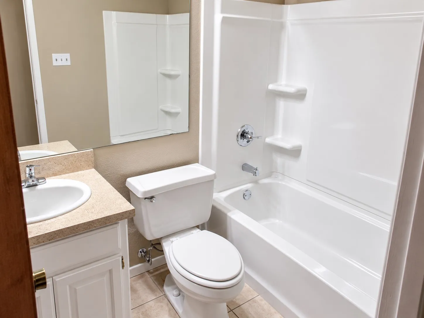 201- White porcelain bathtub with integrated shelving and a chrome fixture
