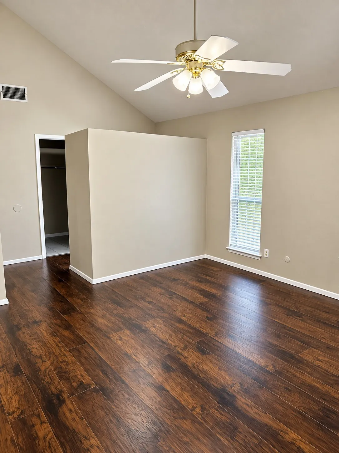 201- Vaulted ceiling with a ceiling fan light fixture, wood-finish flooring, and a window with blinds