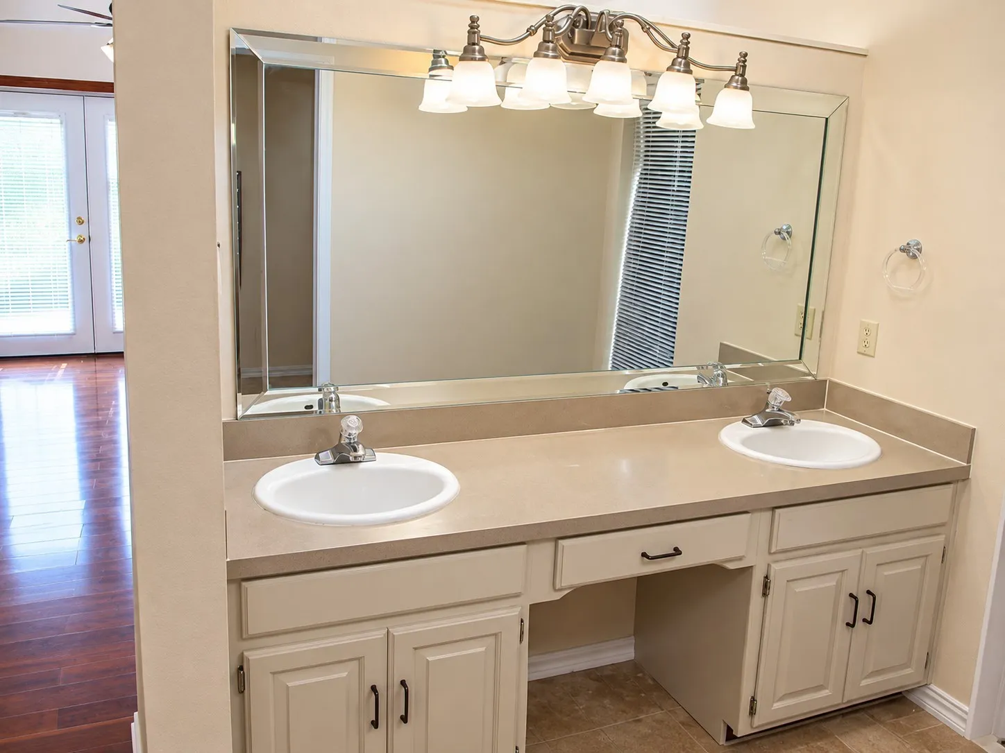 203- Double vanity with integrated sinks, ample countertop space, brushed nickel light fixture, and dedicated cabinetry storage