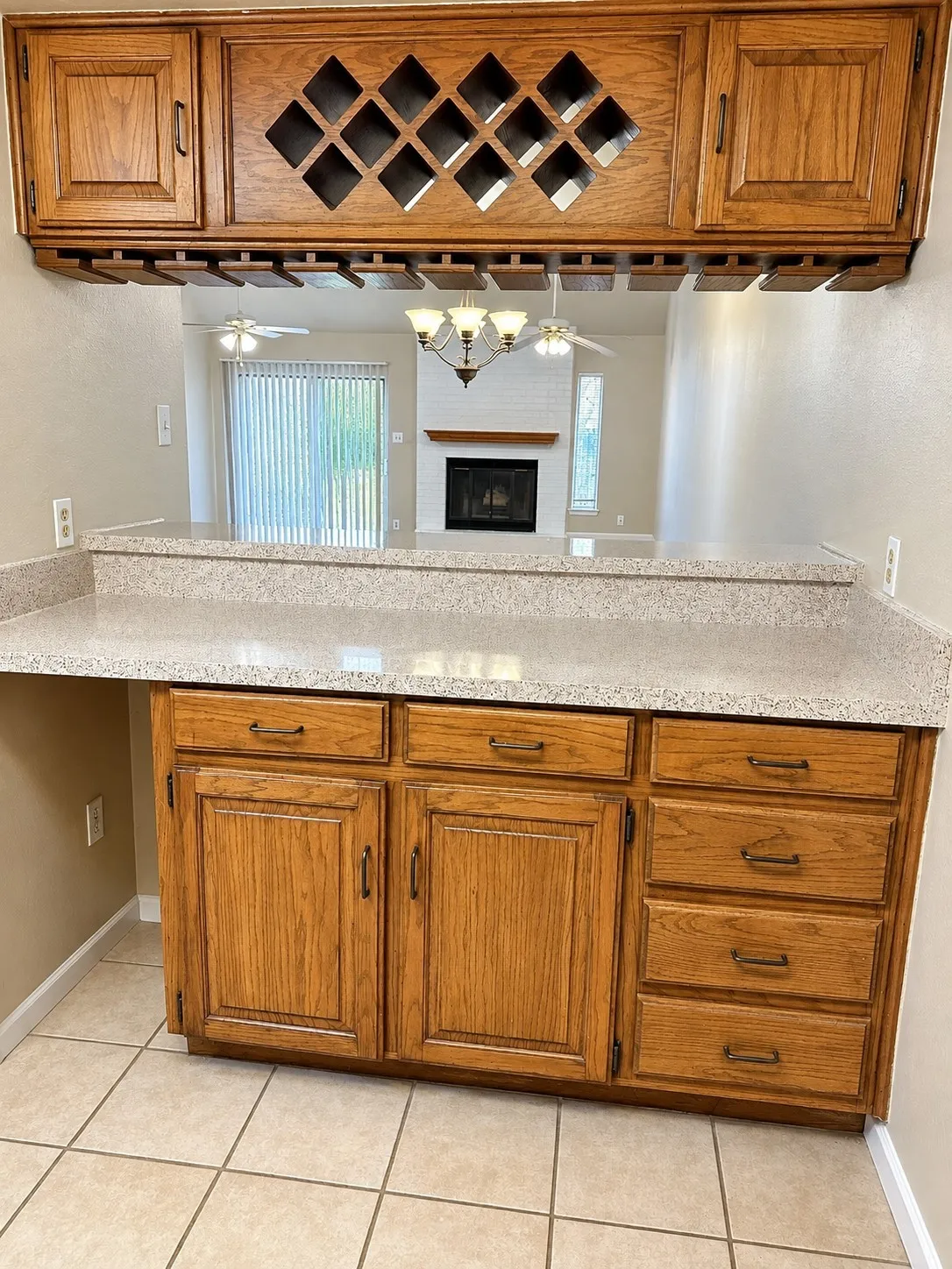 201- Wood-finish cabinetry with multiple storage options, including a built-in wine rack and integrated stemware storage