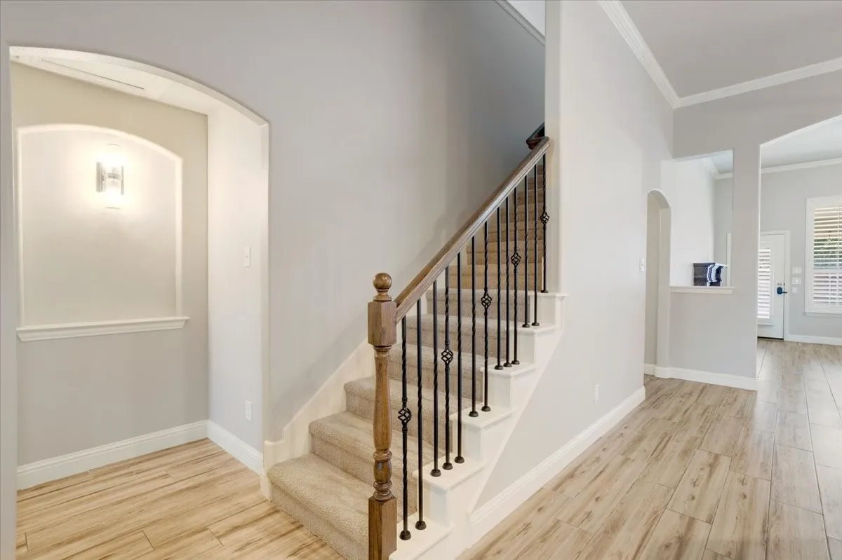 Staircase with wood-finish handrail and wrought iron balusters