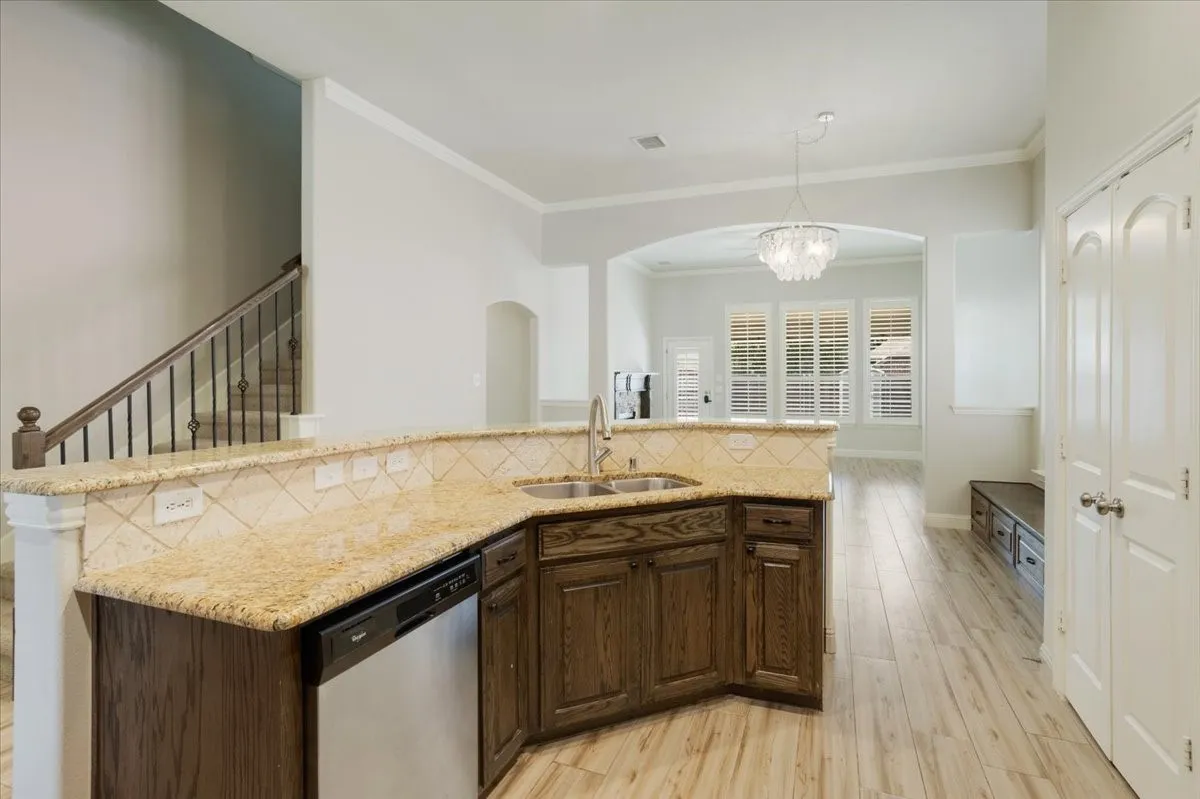 Kitchen featuring granite countertops, a tile backsplash, and dark wood-finish cabinetry