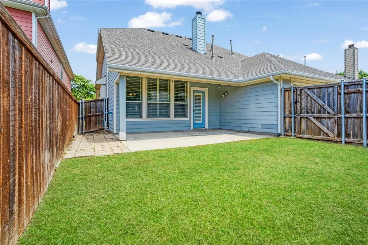 Expansive backyard featuring a concrete patio, a privacy fence, and a side access gate