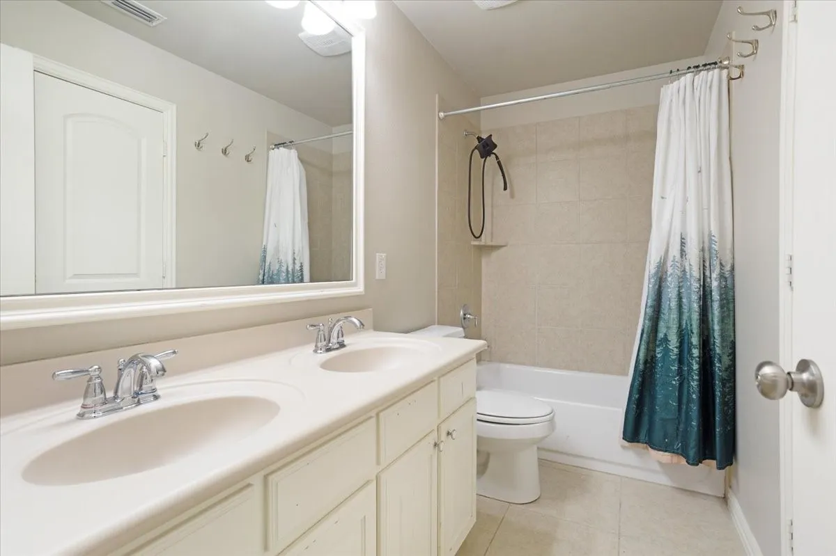 Double vanity with integrated sinks, chrome fixtures, and white cabinetry