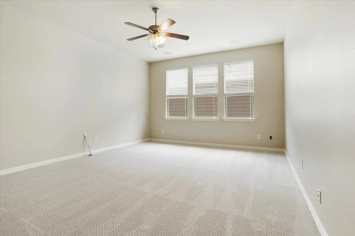 Expansive room with neutral carpet flooring and light-toned walls