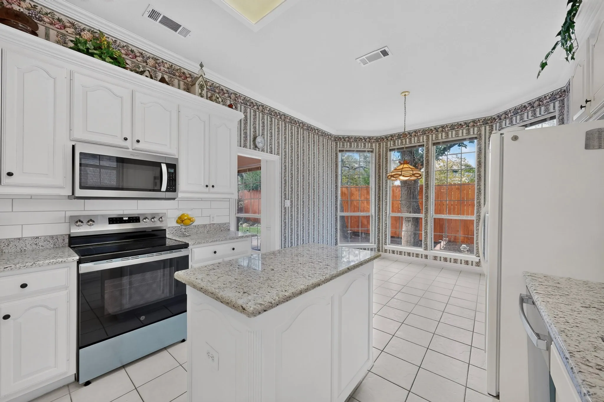 White cabinetry and a center island with granite countertops