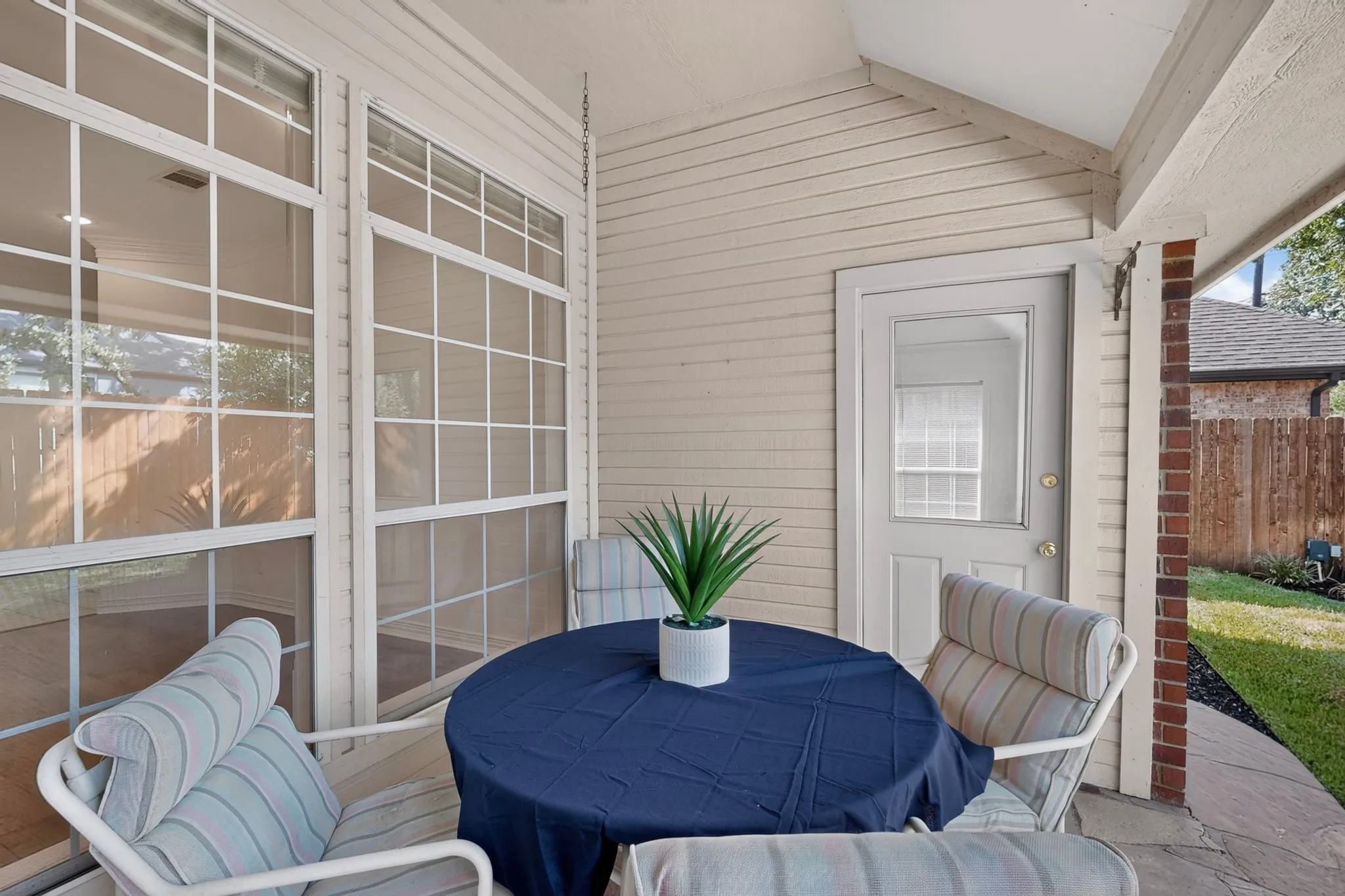 Covered patio with a painted ceiling, stone slab flooring, and a paneled wall