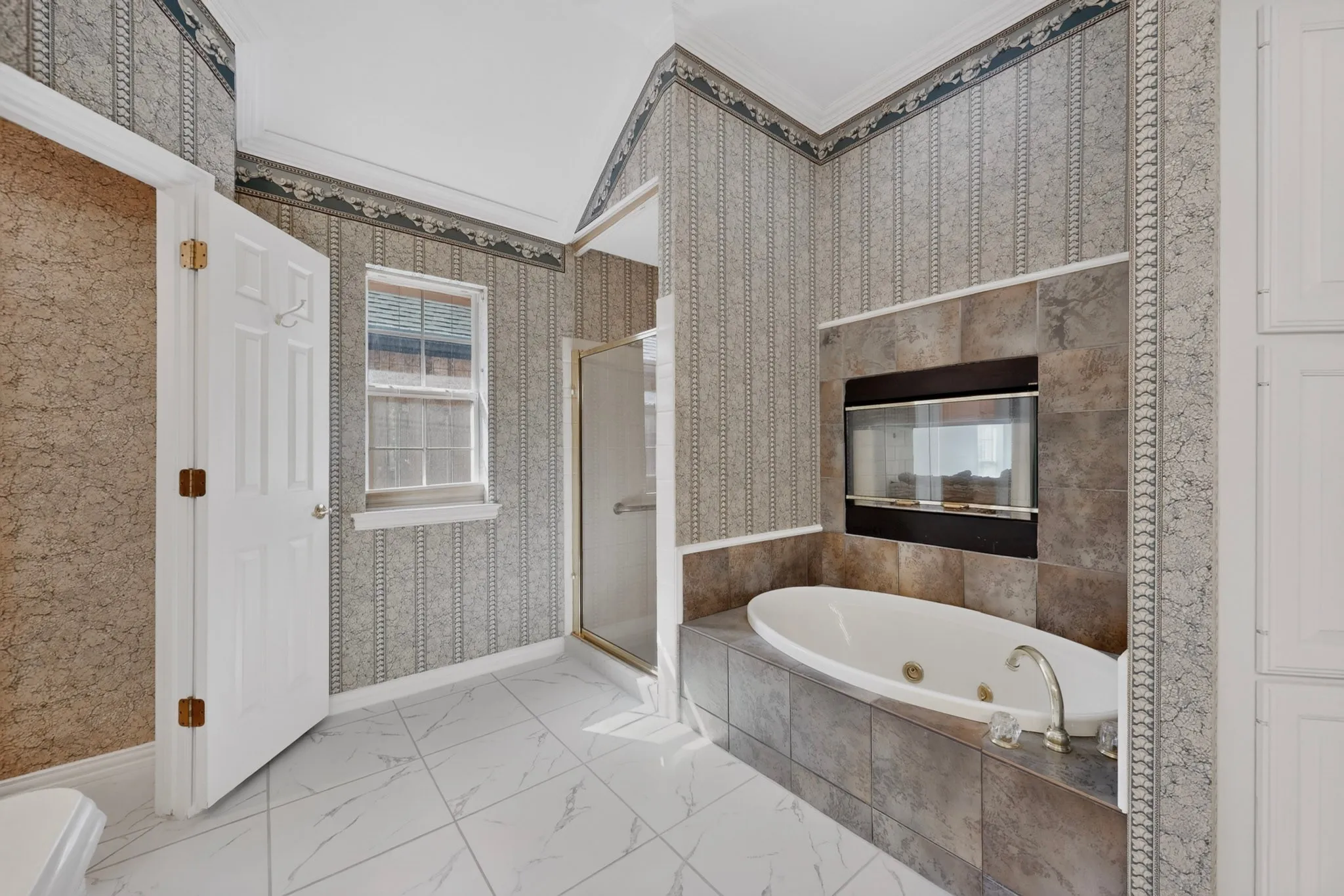 Jetted soaking tub with a tiled surround, integrated fireplace, and a glass-enclosed shower