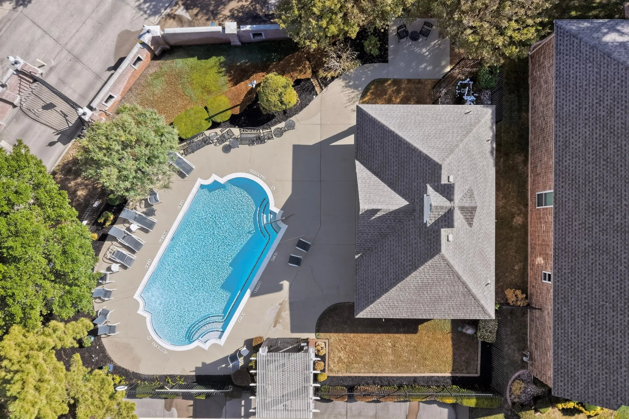 Rectangular swimming pool with integrated steps, surrounded by an expansive concrete patio