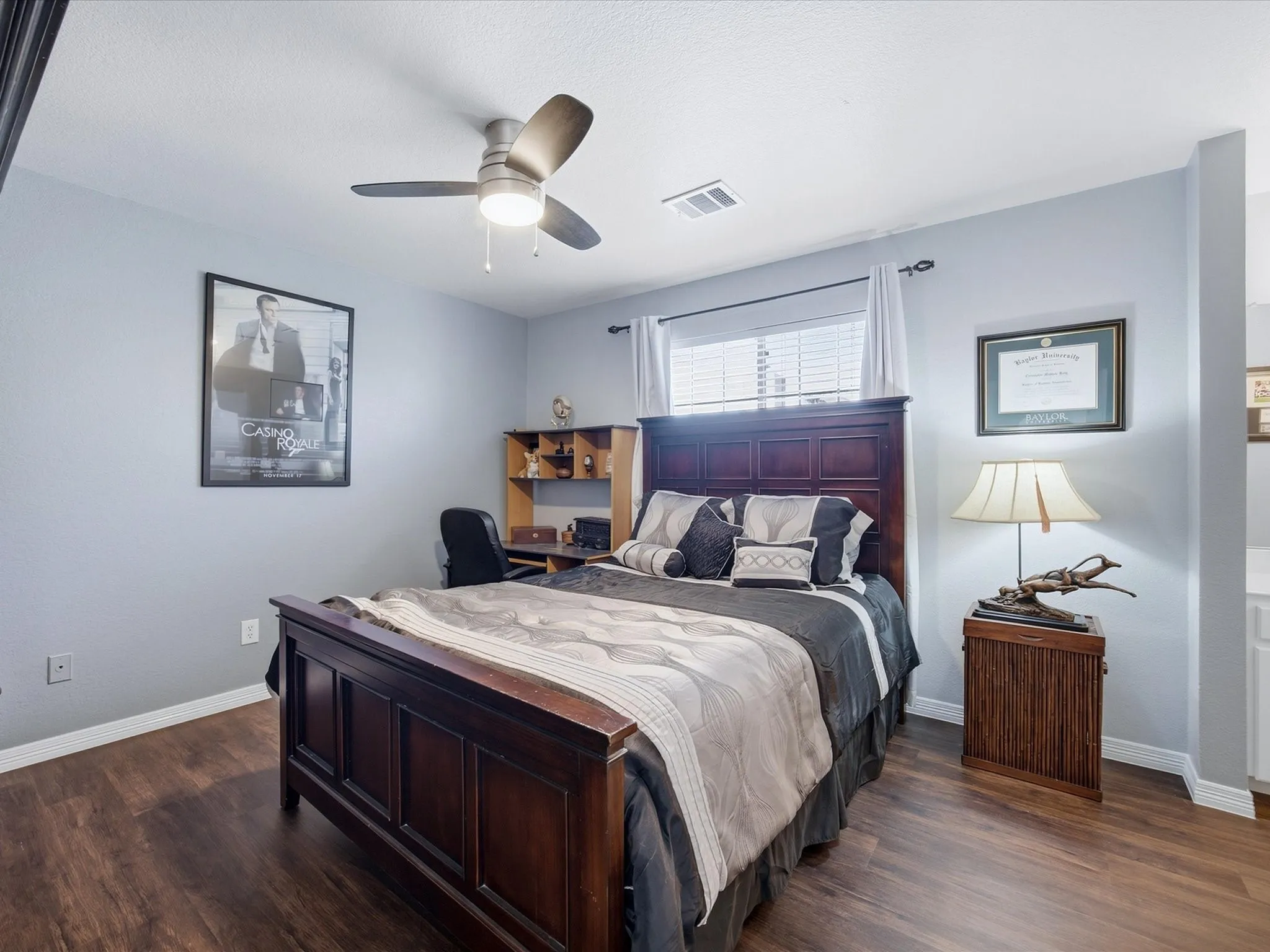 Wood-finish flooring, ceiling fan with integrated lighting, window with blinds, and white trim