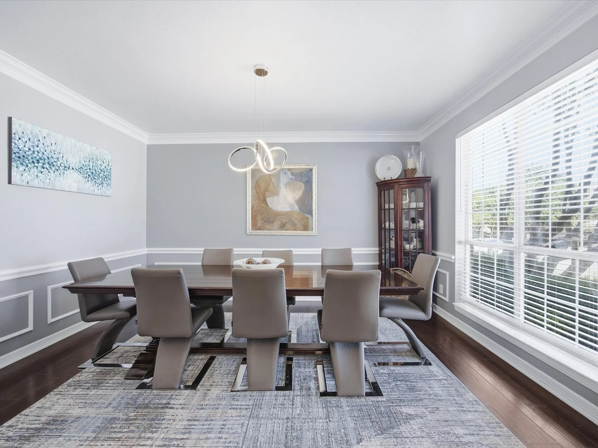 Crown molding, chair rail, wood-finish flooring, and a large window