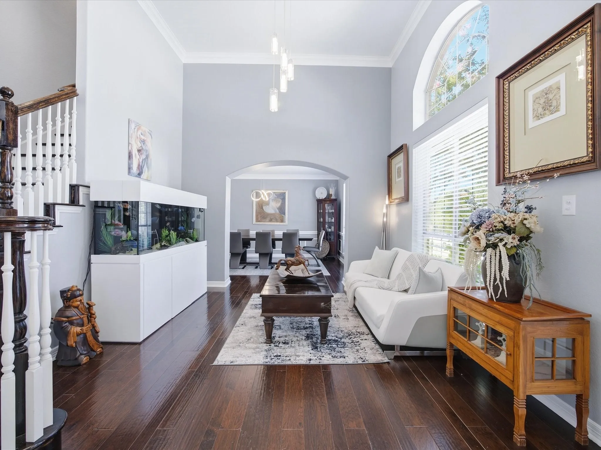 Hardwood-style flooring throughout, with a grand staircase featuring white spindles and dark wood newel posts