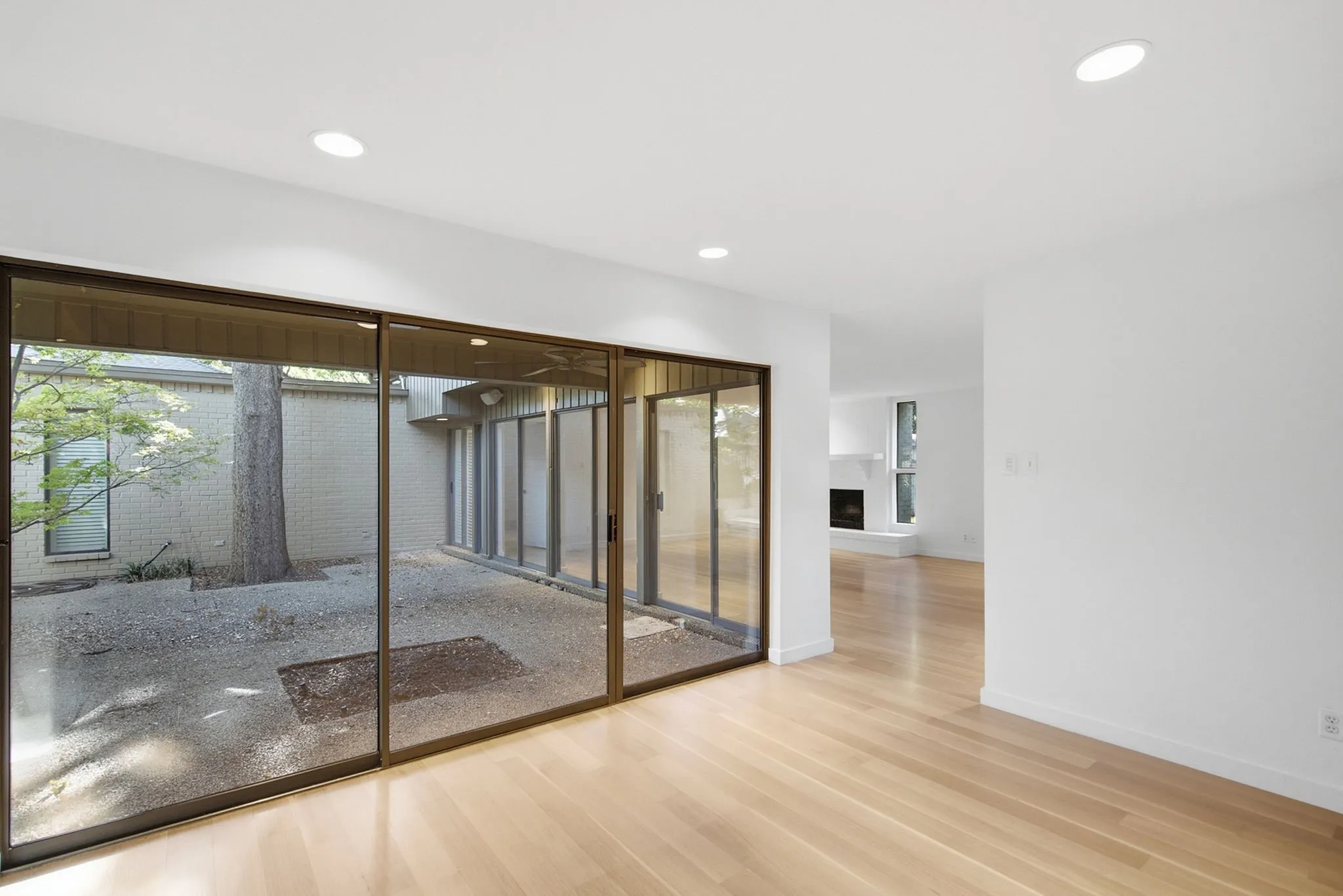 Living and Dining Rooms look out to the courtyard with walls of sliding glass doors