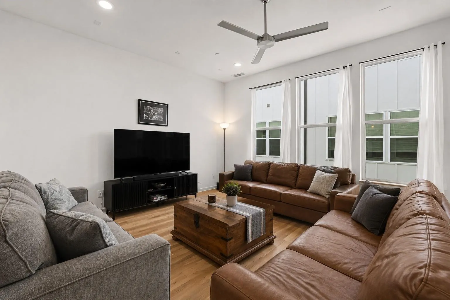 High ceilings with recessed lighting, wood-finish flooring, and multiple large windows