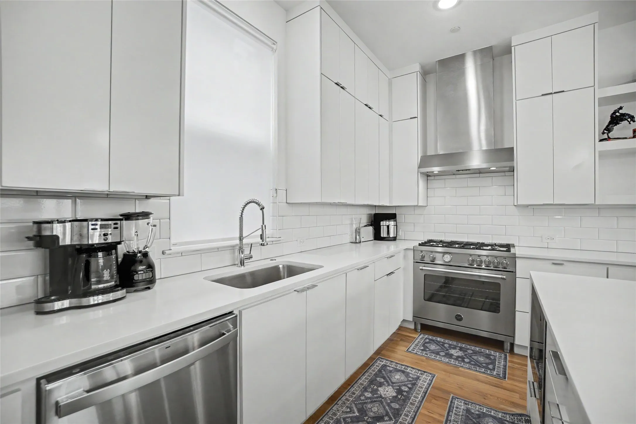 White cabinetry and countertops with stainless steel appliances