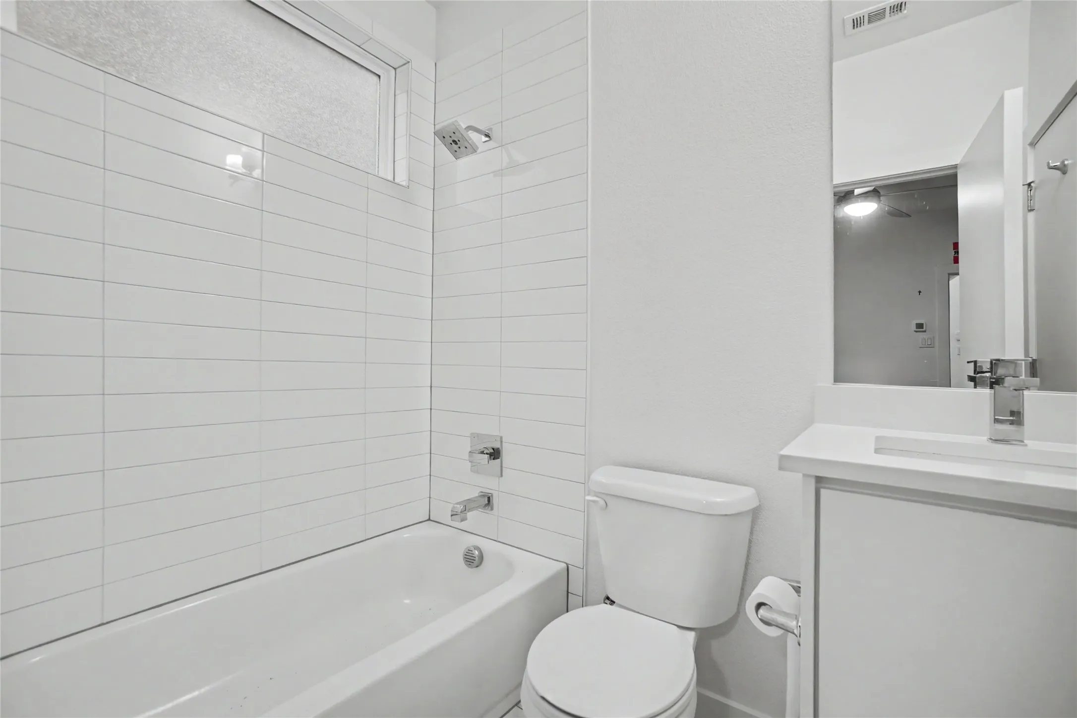 White subway tile shower surround with a fixed showerhead and single-handle faucet
