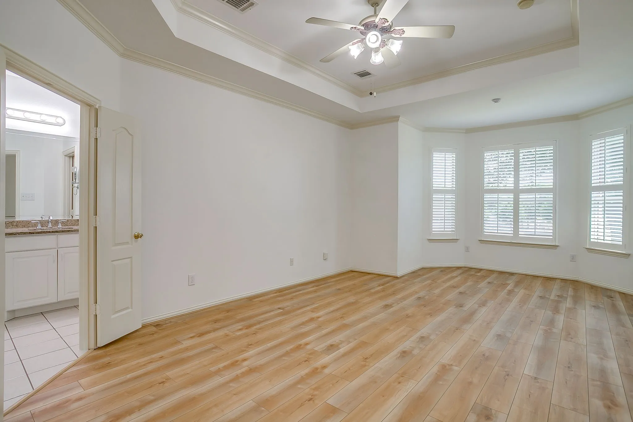 Primary bedroom with bay window overlooking the backyard.