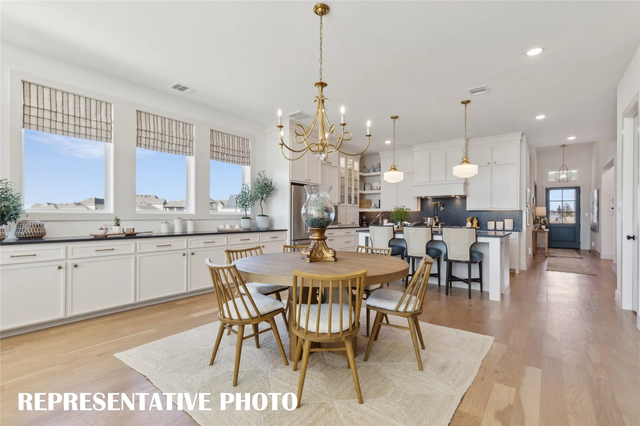 The spacious light filled dining room offers a row of cabinets creating the ideal serving space when hosting lively dinner parties or family get togethers.  REPRESENTATIVE PHOTO