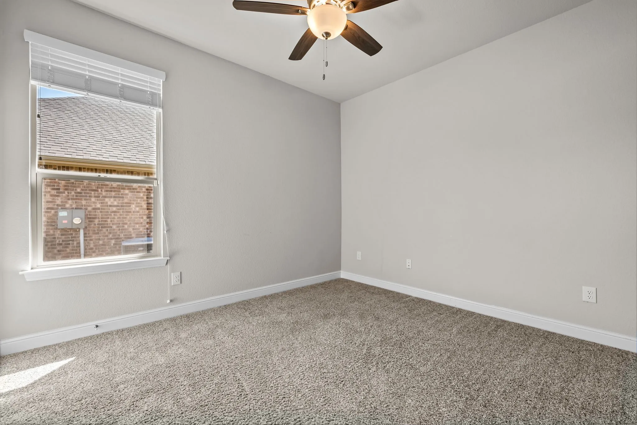 Wall-to-wall carpeting, single window with blinds, ceiling fan with integrated lighting, and neutral wall paint