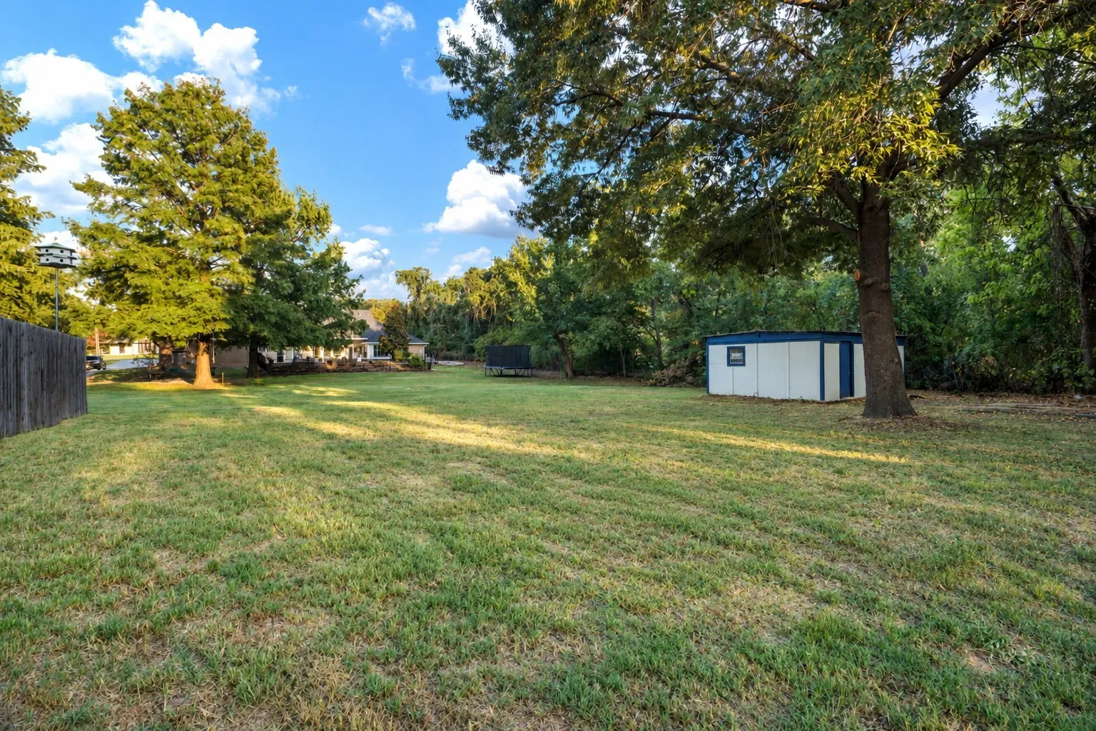 View from the rear of the yard highlights the powered storage shed, featuring a large roll-up door for convenient access.