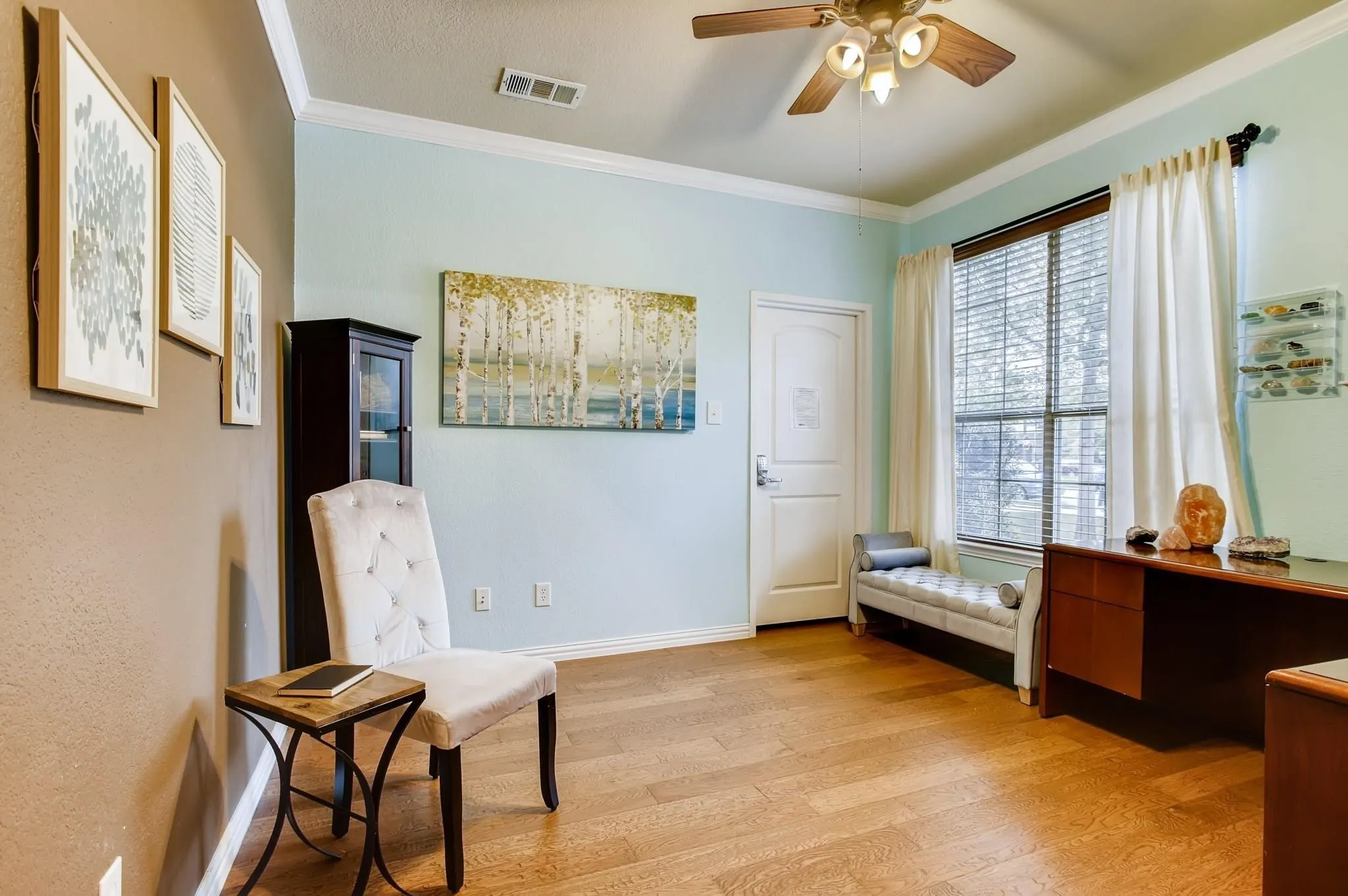 Wood-finish flooring, crown molding, ceiling fan, and window blinds