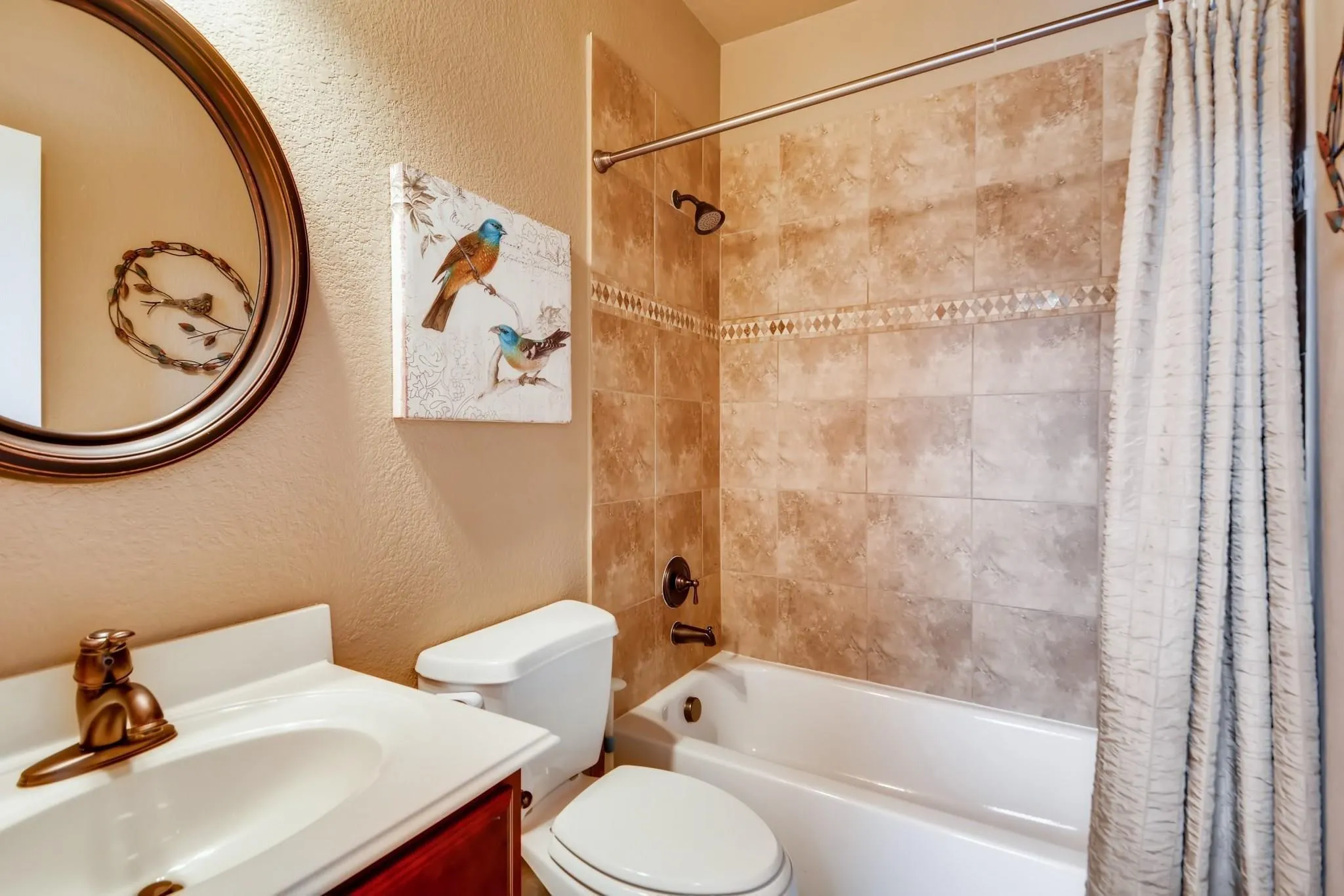 Tub and shower combination with full-height tile surround featuring a decorative mosaic accent band