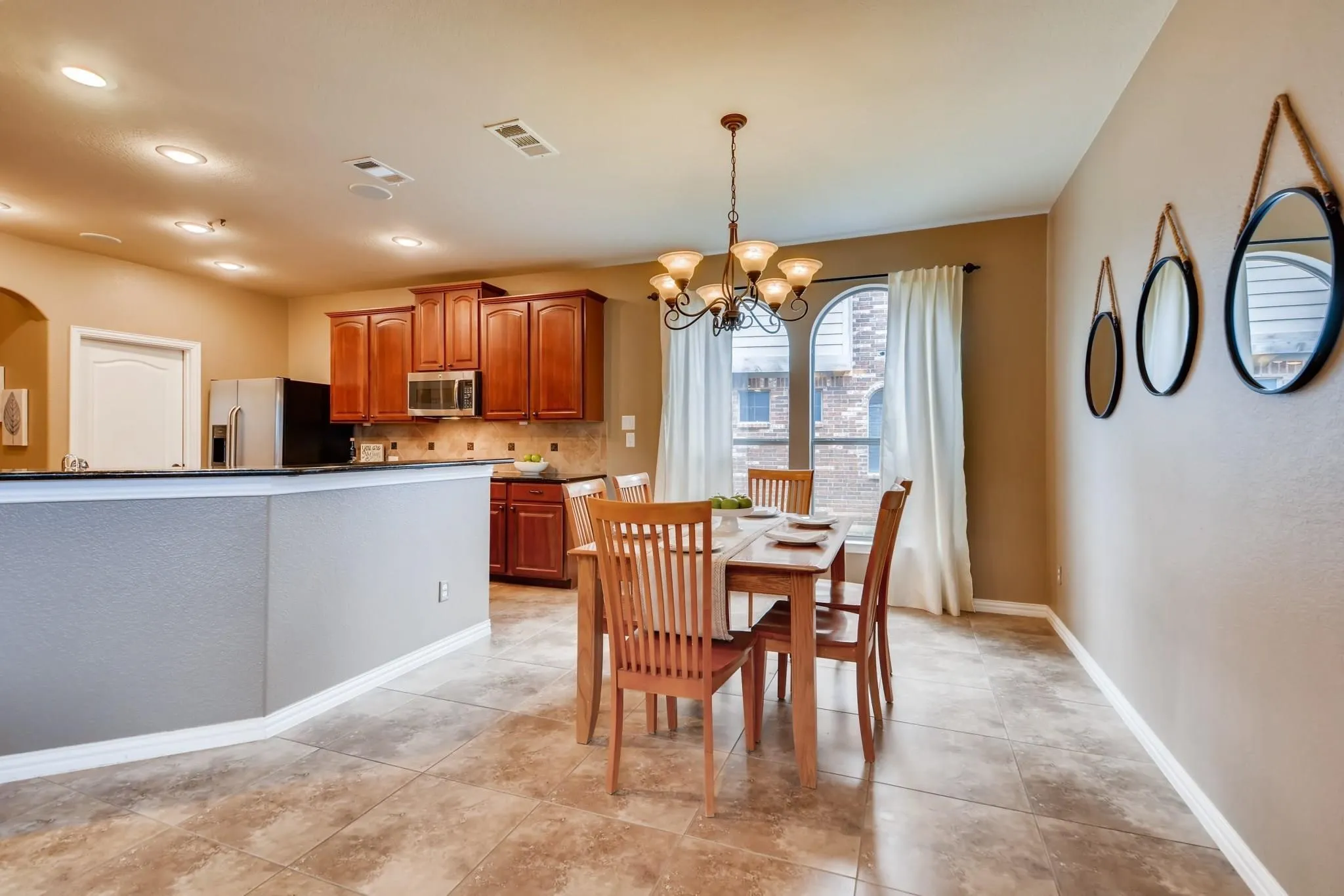 Open-concept dining area with tile flooring and a chandelier