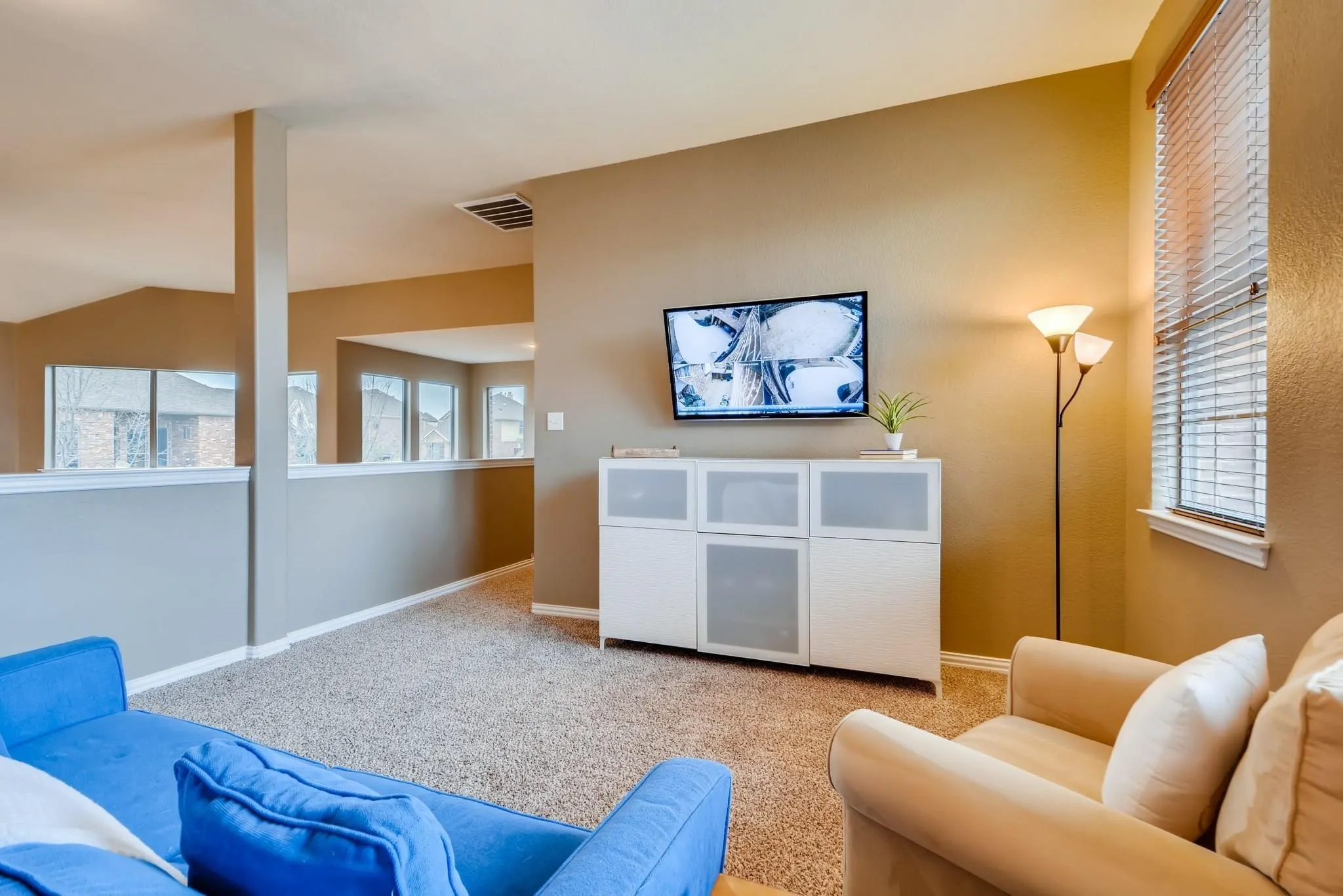 Carpeted flooring throughout, neutral wall paint, and multiple windows with blinds