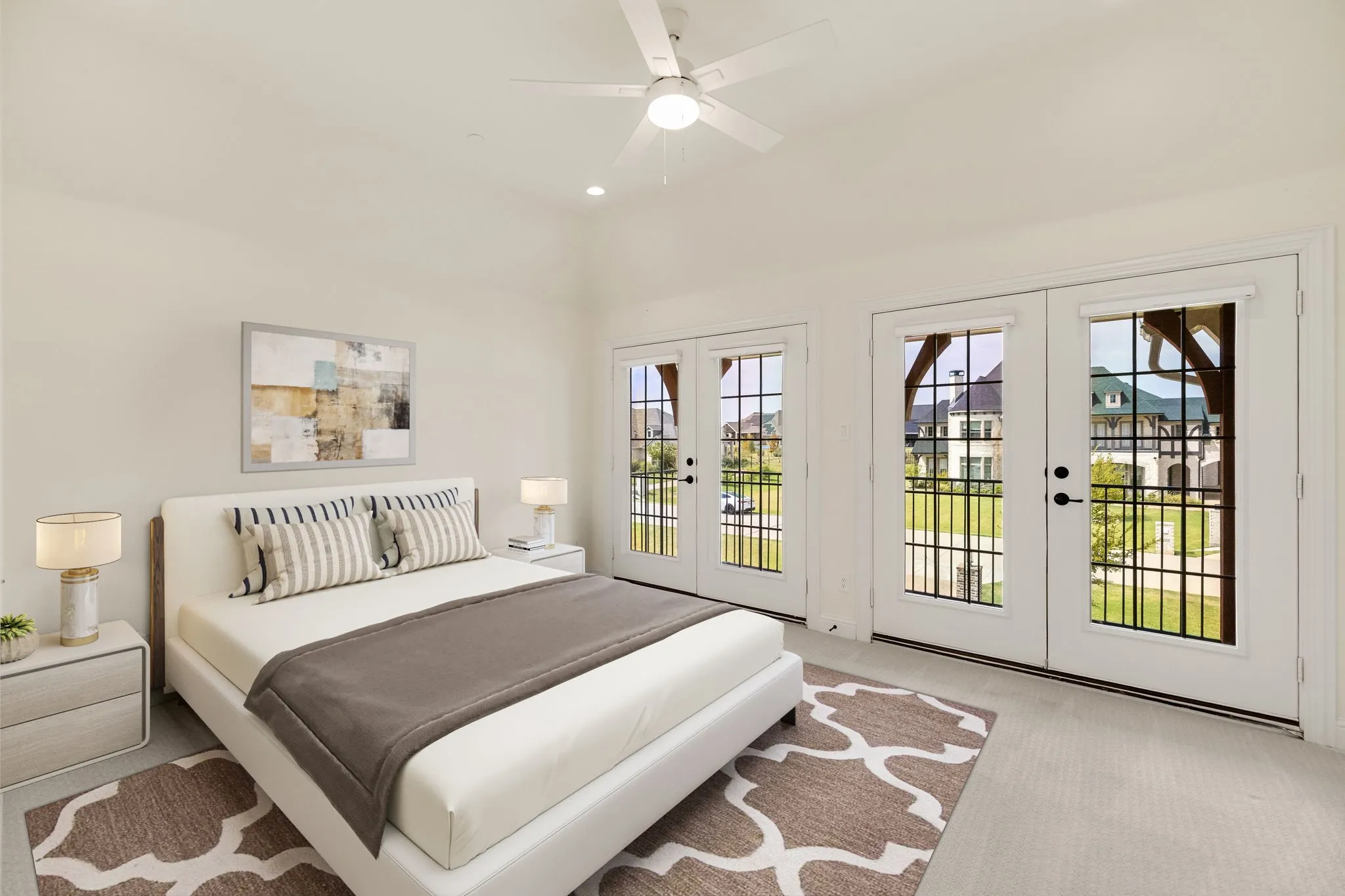 Bedroom virtually staged, Vaulted ceiling with a ceiling fan, recessed lighting, and two sets of French doors with transom windows