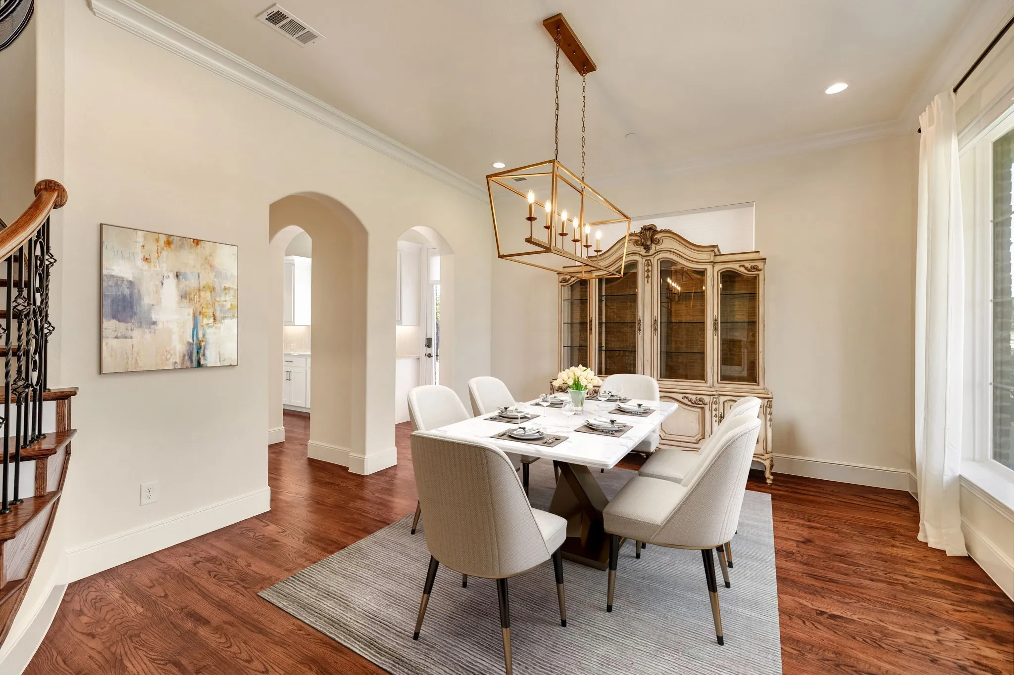 Dining Room virtually staged, Warm wood-finish flooring, arched doorways, a coffered ceiling, recessed lighting, and a prominent window