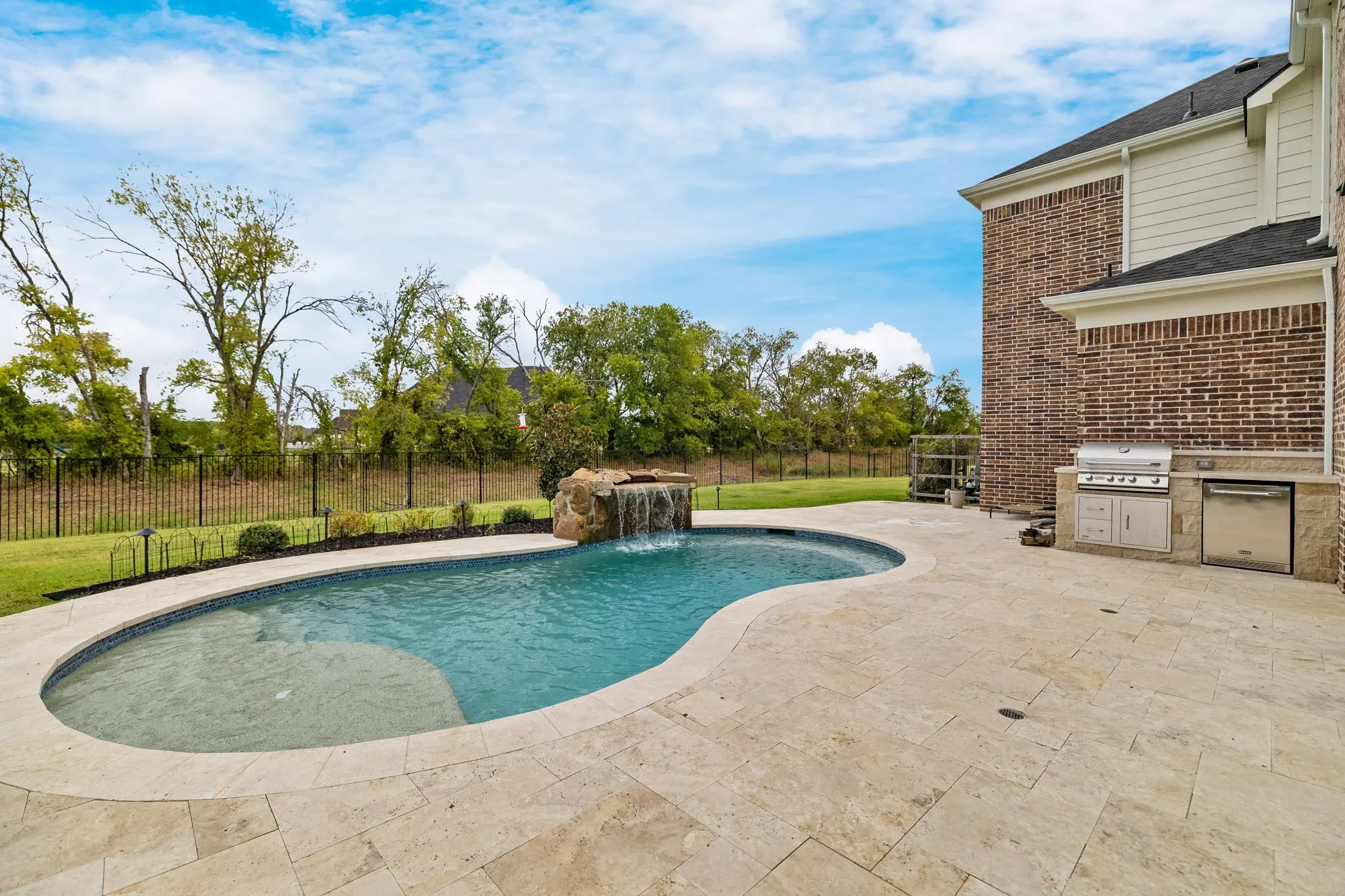 Custom-shaped pool with rock waterfall feature