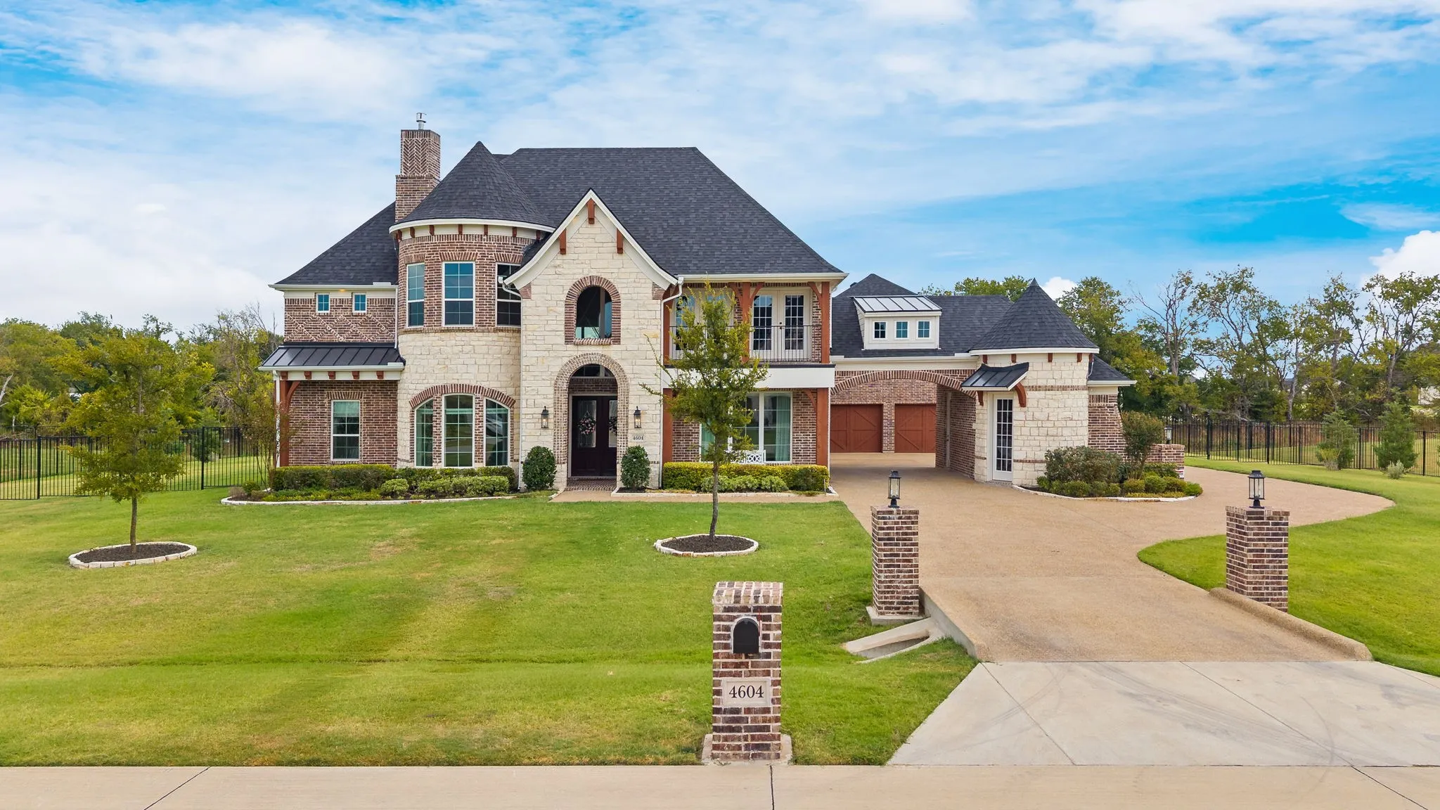 Two-story residence featuring brick and stone masonry, multiple gables, and a prominent chimney