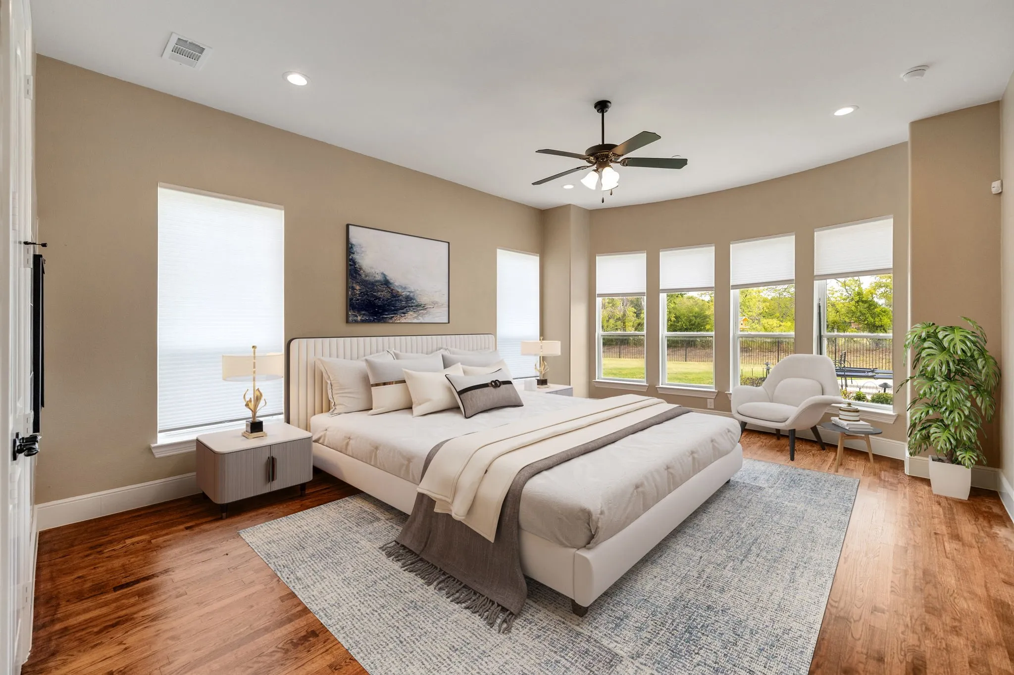 Primary bedroom virtually staged, Recessed lighting, ceiling fan, wood-finish flooring, multiple windows, and a neutral wall palette