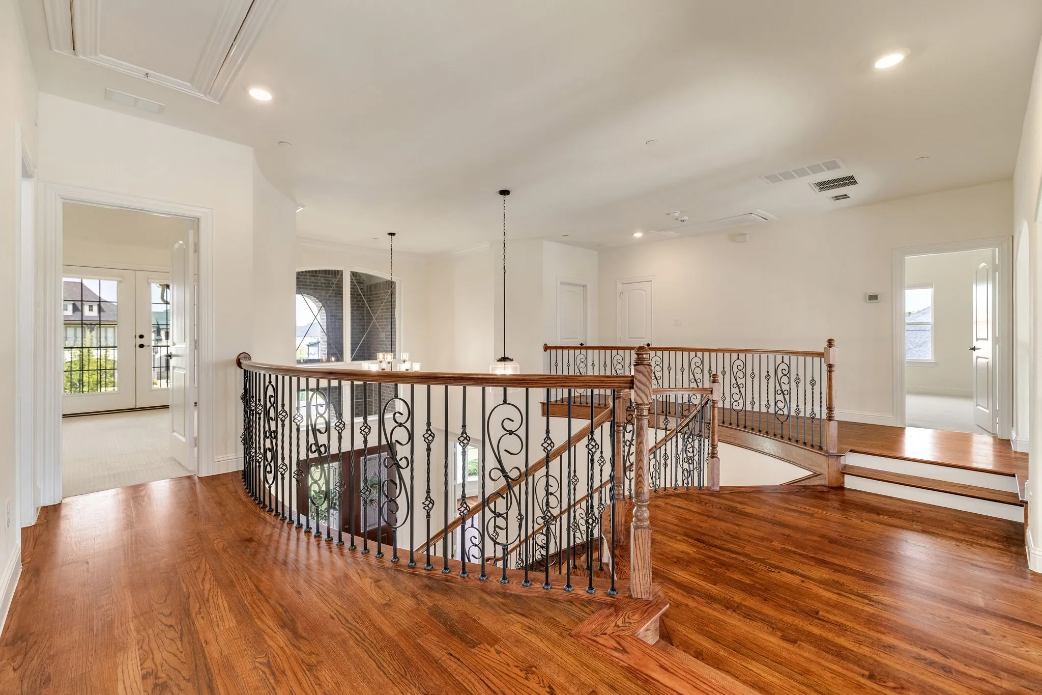 Hardwood flooring with a decorative wrought iron and wood staircase