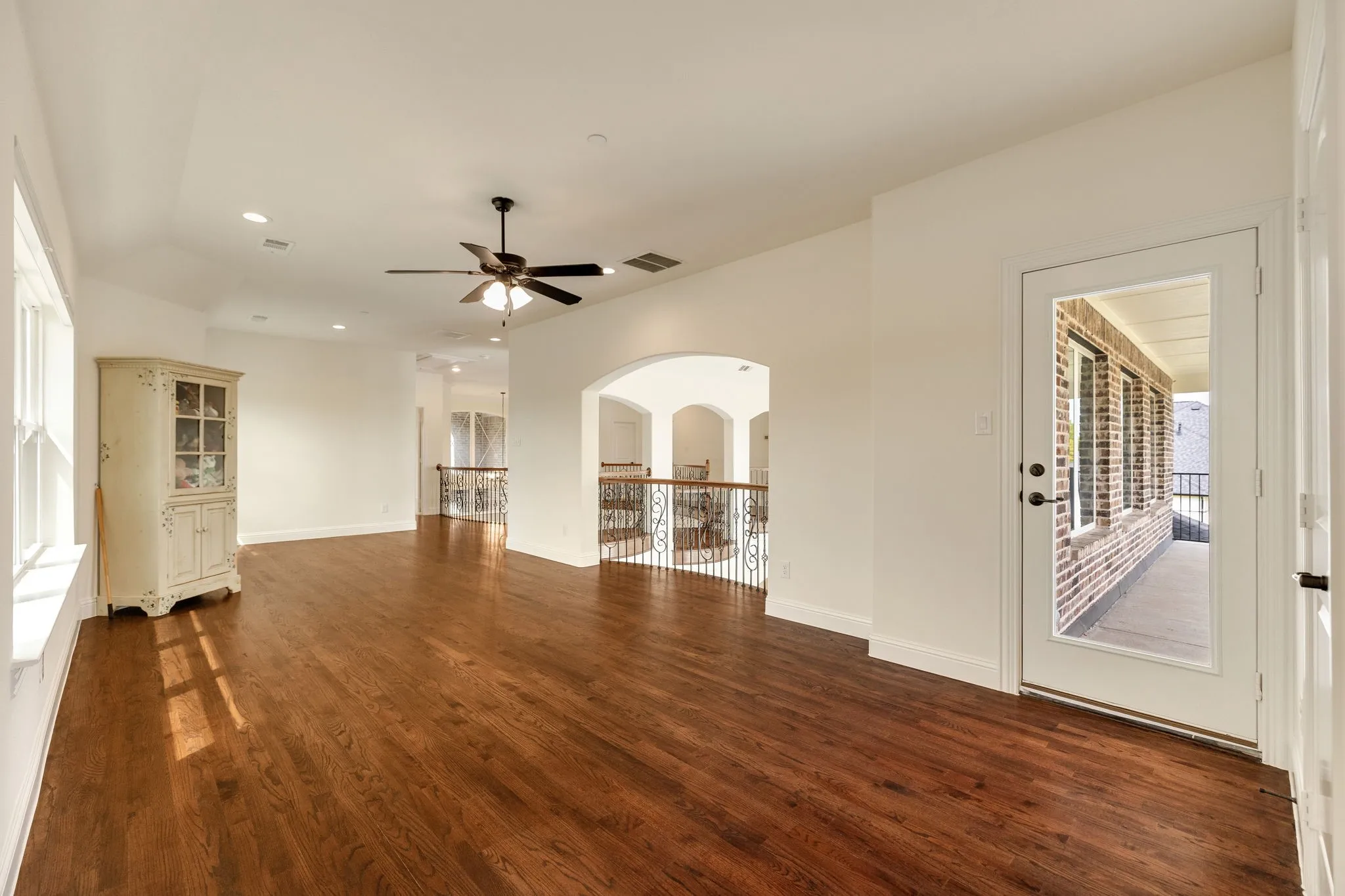 Spacious room with wood-finish flooring, vaulted ceiling, and recessed lighting