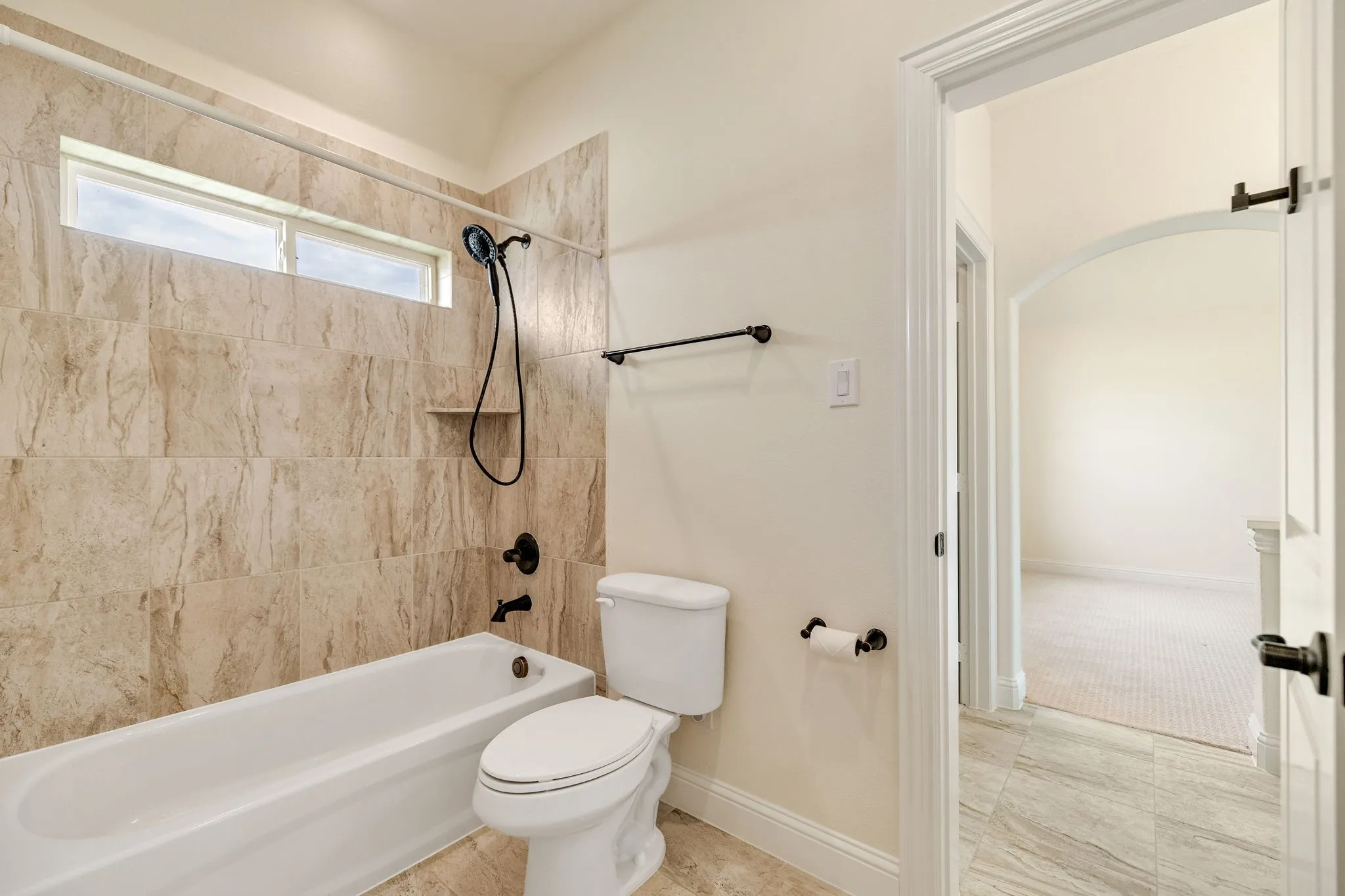 Tub/shower combination with tile surround and black fixtures