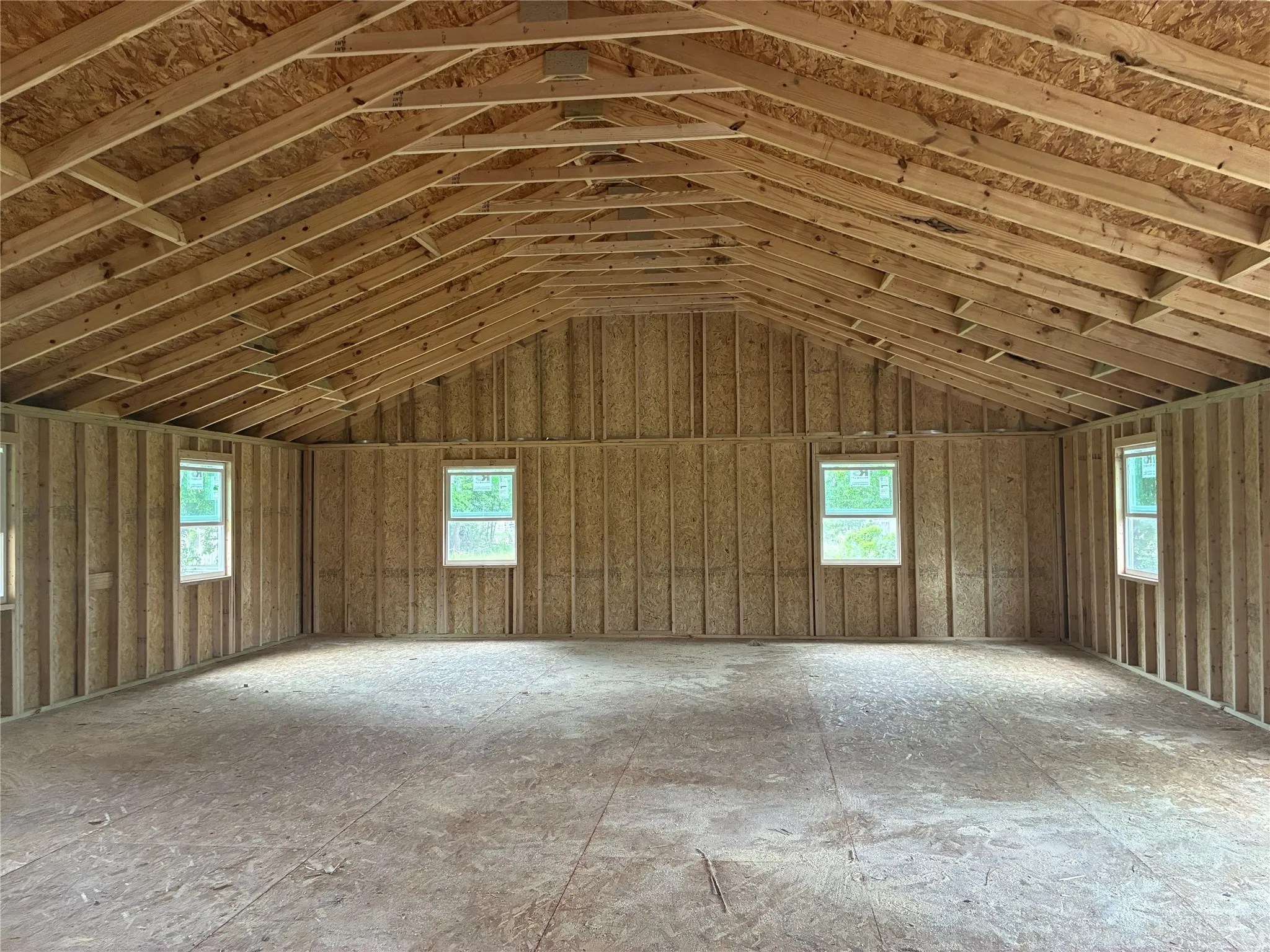Vaulted ceiling framing, exposed rafters, and multiple windows