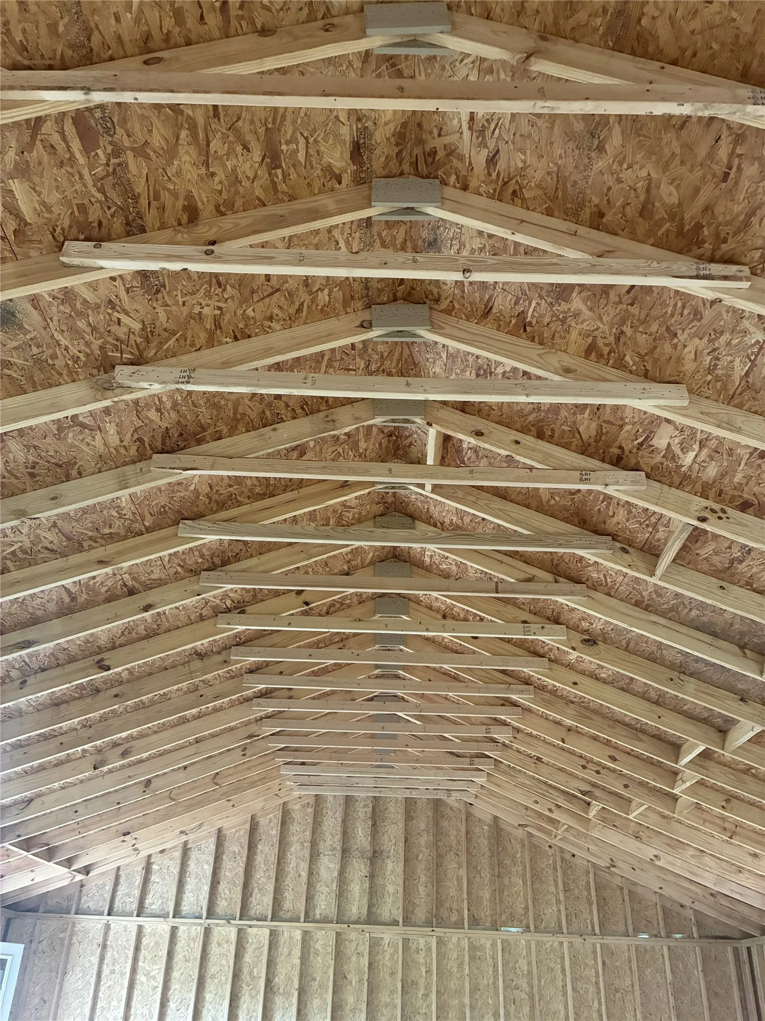 Exposed wood truss ceiling with oriented strand board sheathing