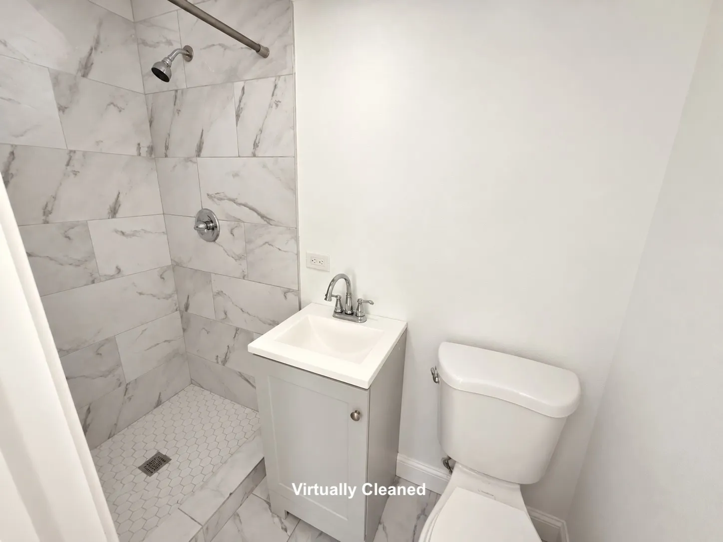 Walk-in shower with marble-look tile surround and hexagonal tile floor
