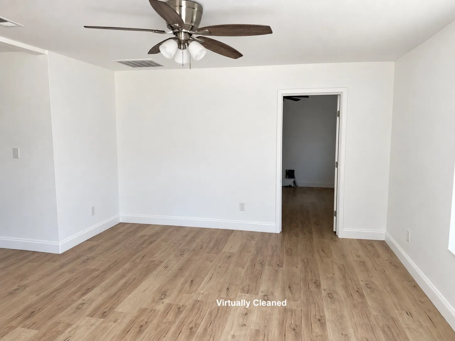 Neutral color palette with wood-finish flooring, white walls, and a ceiling fan with integrated lighting