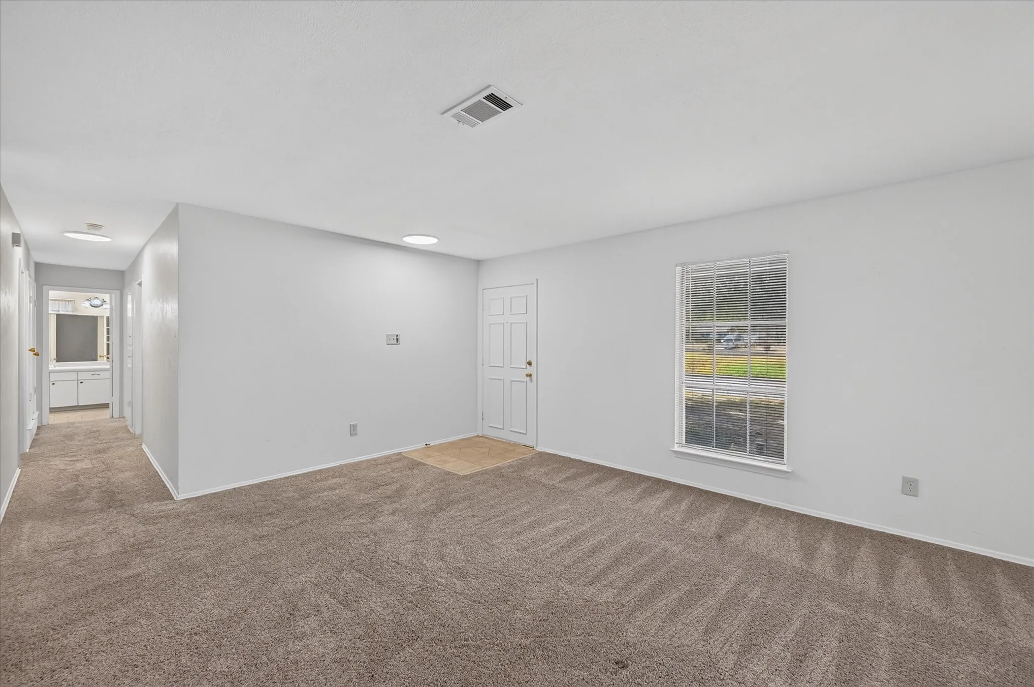 Entryway to the living room and a window with a view of the front yard