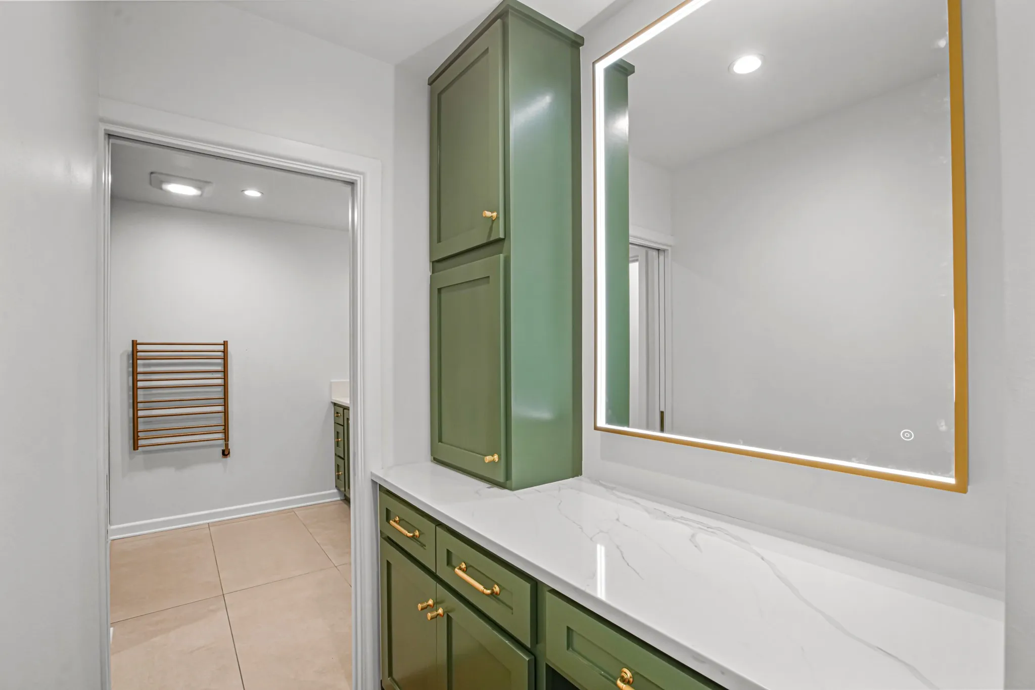 Dedicated vanity area with quartz counters, custom cabinets, gold-tone hardware and illuminated mirror sure makes getting ready every morning nice!