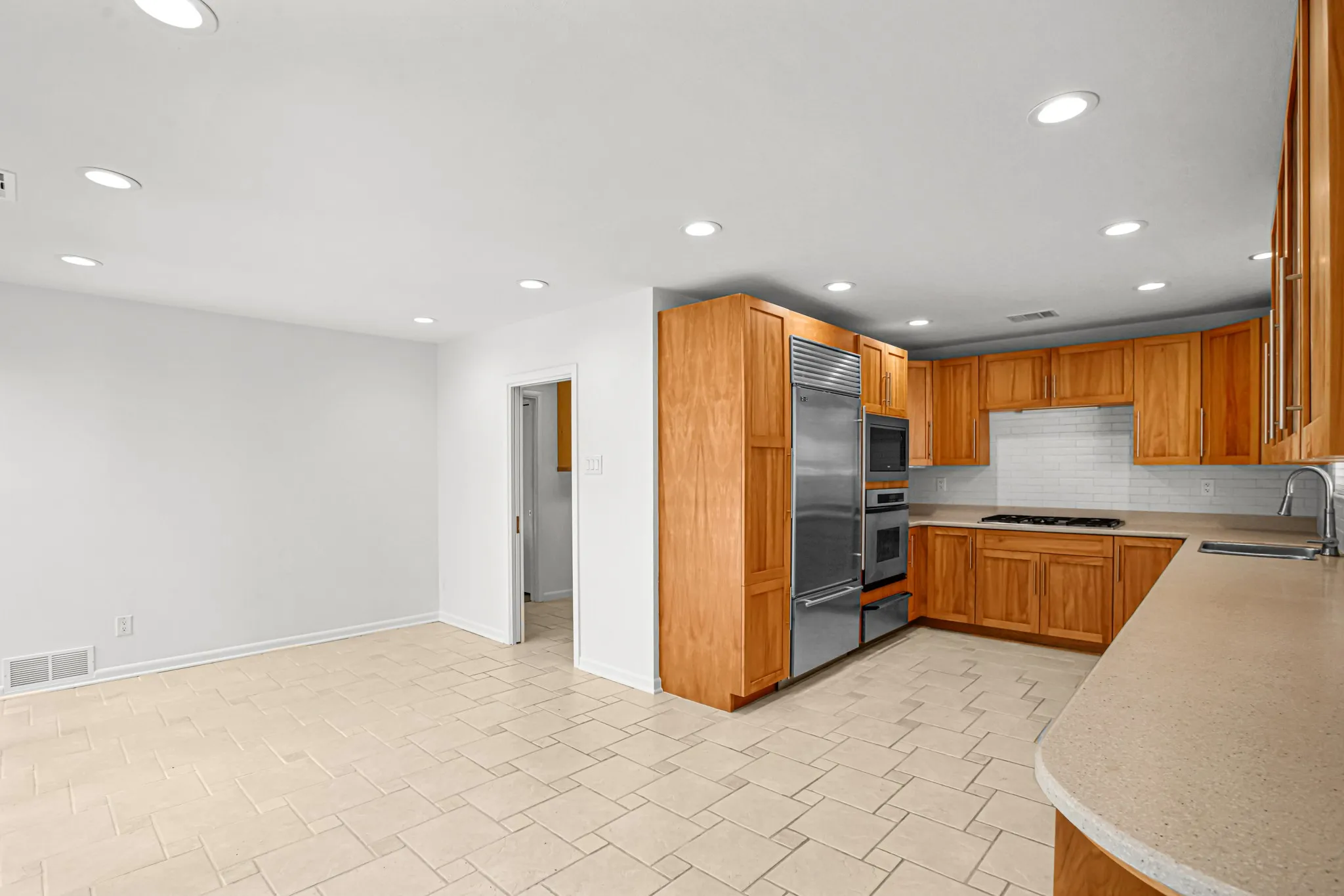 The kitchen features a high end appliance package including a built-in Sub-Zero Refrigerator and Freezer combo, Dacor 5-Burner Gas Cooktop and Oven, Warming Drawer, Microwave and Bosch Dishwasher.